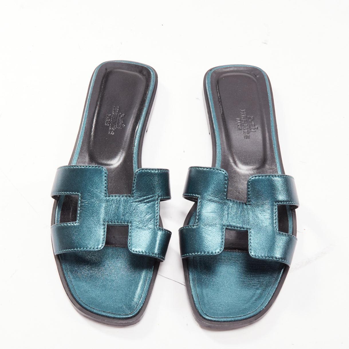 HERMES Oran metallic blue leather H flat mules slipper sandals EU37.5
Reference: LNKO/A02368
Brand: Hermes
Model: Oran
Material: Leather
Color: Blue
Pattern: Solid
Closure: Slip On
Lining: Black Leather
Extra Details: They feature a toe strap of a