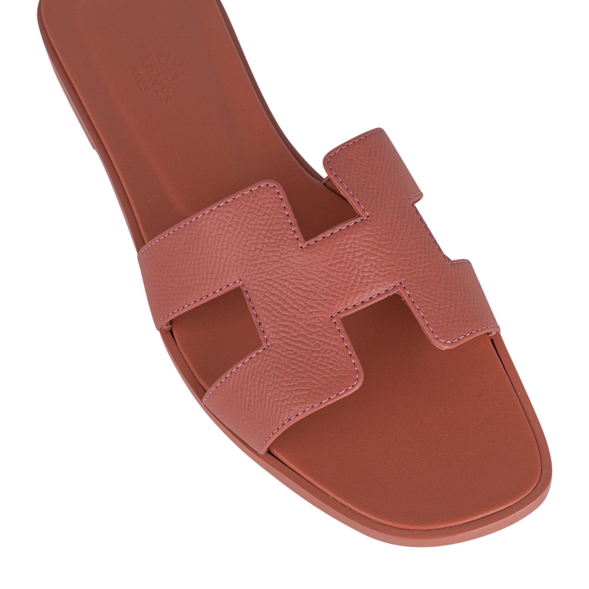 Mightychic offers a guaranteed authentic Hermes Oran Rose Aube sandals.
These soft duty pink flat slides are a must for foot flirting!
The iconic top stitched H cutout over the top of the foot in Epsom leather.
Hermes Paris embossed Rose Aube