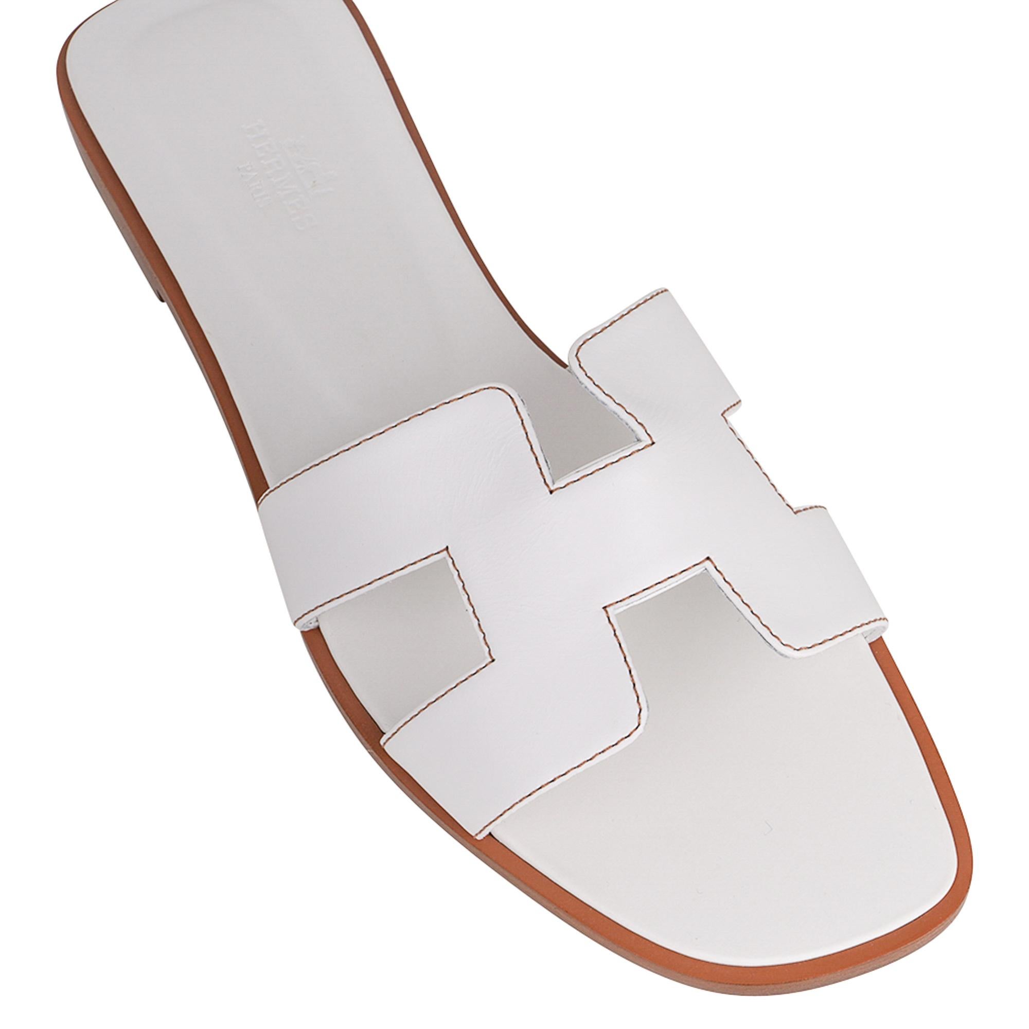 Mightychic offers an Hermes Oran sandal iconic slide featured in White with Havane topstitch.
The signature H cutout over the top of the foot in sublime calfskin.
White embossed calfskin insole. 
Wood heel with leather sole. 
Comes with sleepers,