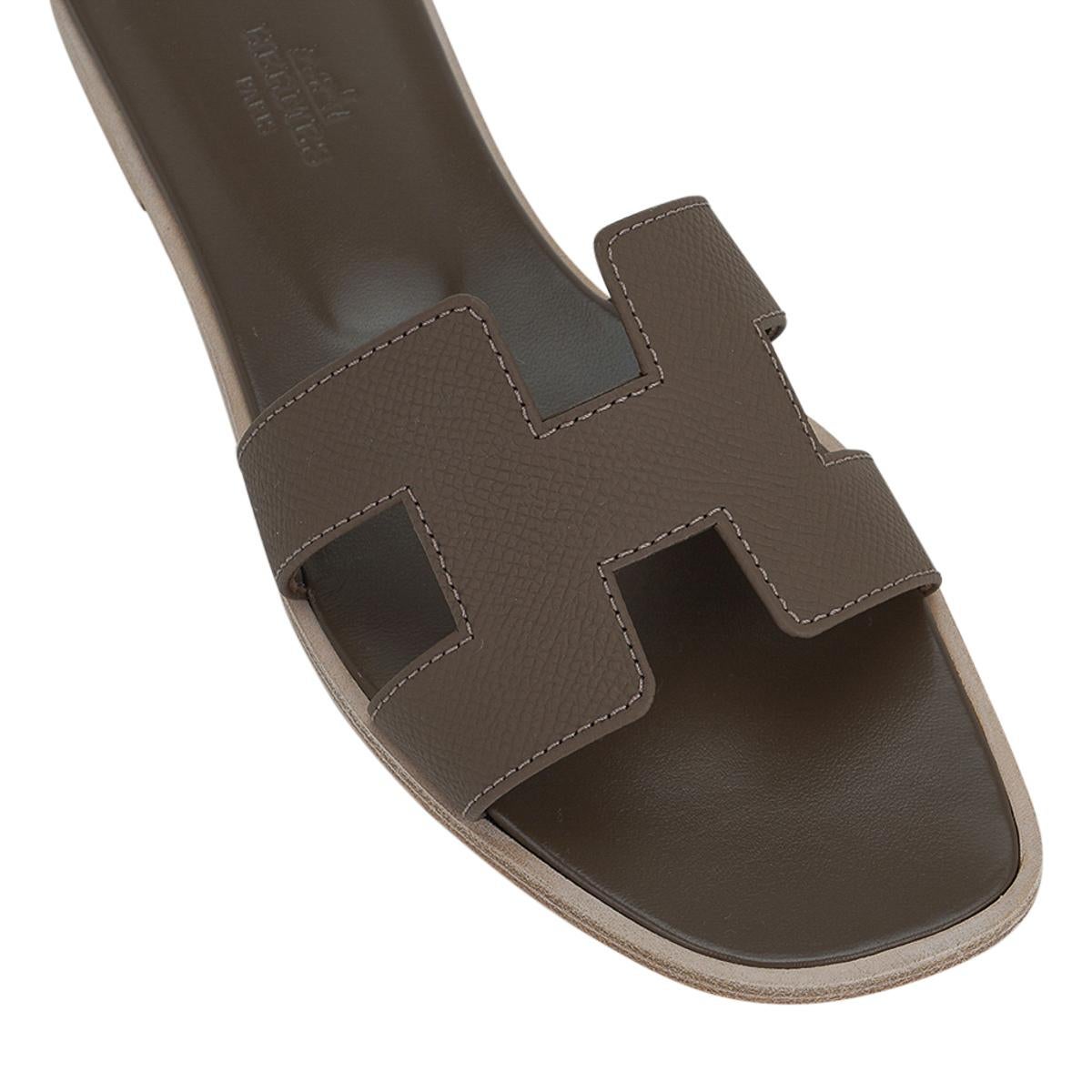 Mightychic offers Hermes Oran sandal shoes featured in neutral Etoupe Epsom leather. 
The iconic top stitched H cutout over the top of the slide.
Matching embossed calfskin insole.
Wood heel with leather sole.
Comes with sleepers and signature