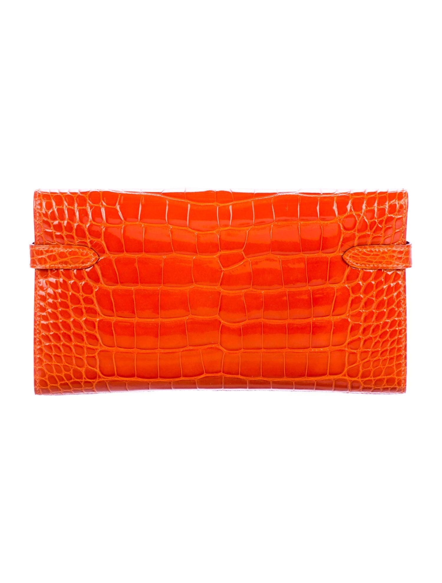 Hermes Orange Alligator Palladium  Evening Kelly Clutch Wallet Bag in Box

Alligator 
Palladium tone hardware
Turnlock closure
Leather lining
Date code present
Made in France
Features zip closure, bill compartment and 12 card slots 
Measures 7.75