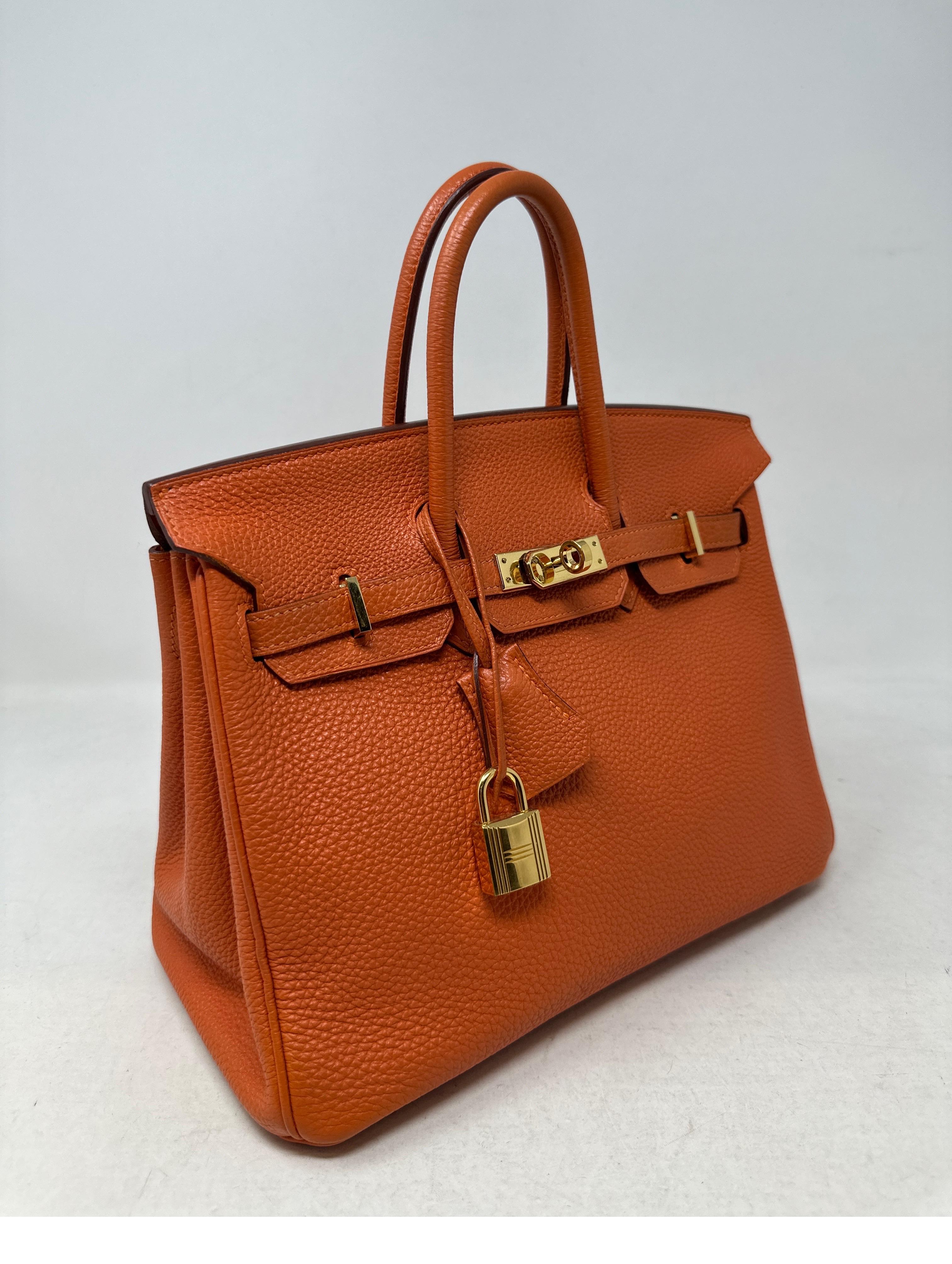 Hermes Orange Birkin 25 Bag. Togo leather. Gold hardware. Mini Birkin is so rare now. Interior is clean. Good condition. Includes clcohette, lock, keys, and dust bag. Guaranteed authentic. 