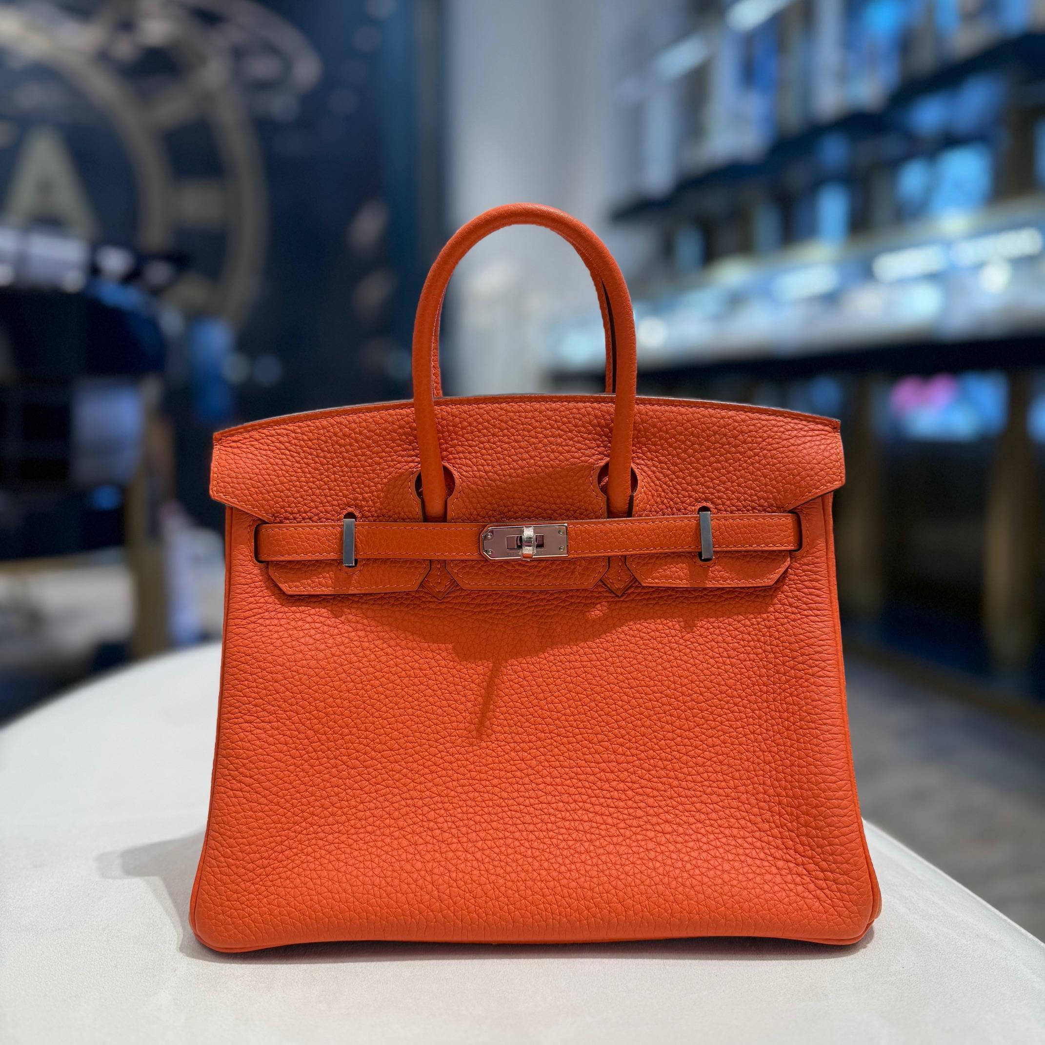 Jewels Aficionado bietet die Hermès Orange Birkin 25 an, die aus Togo-Leder mit strukturiertem Finish und robuster Struktur gefertigt ist. Der leuchtende Orangeton verleiht ihm einen kräftigen, energiegeladenen Touch und macht ihn zu einem perfekten