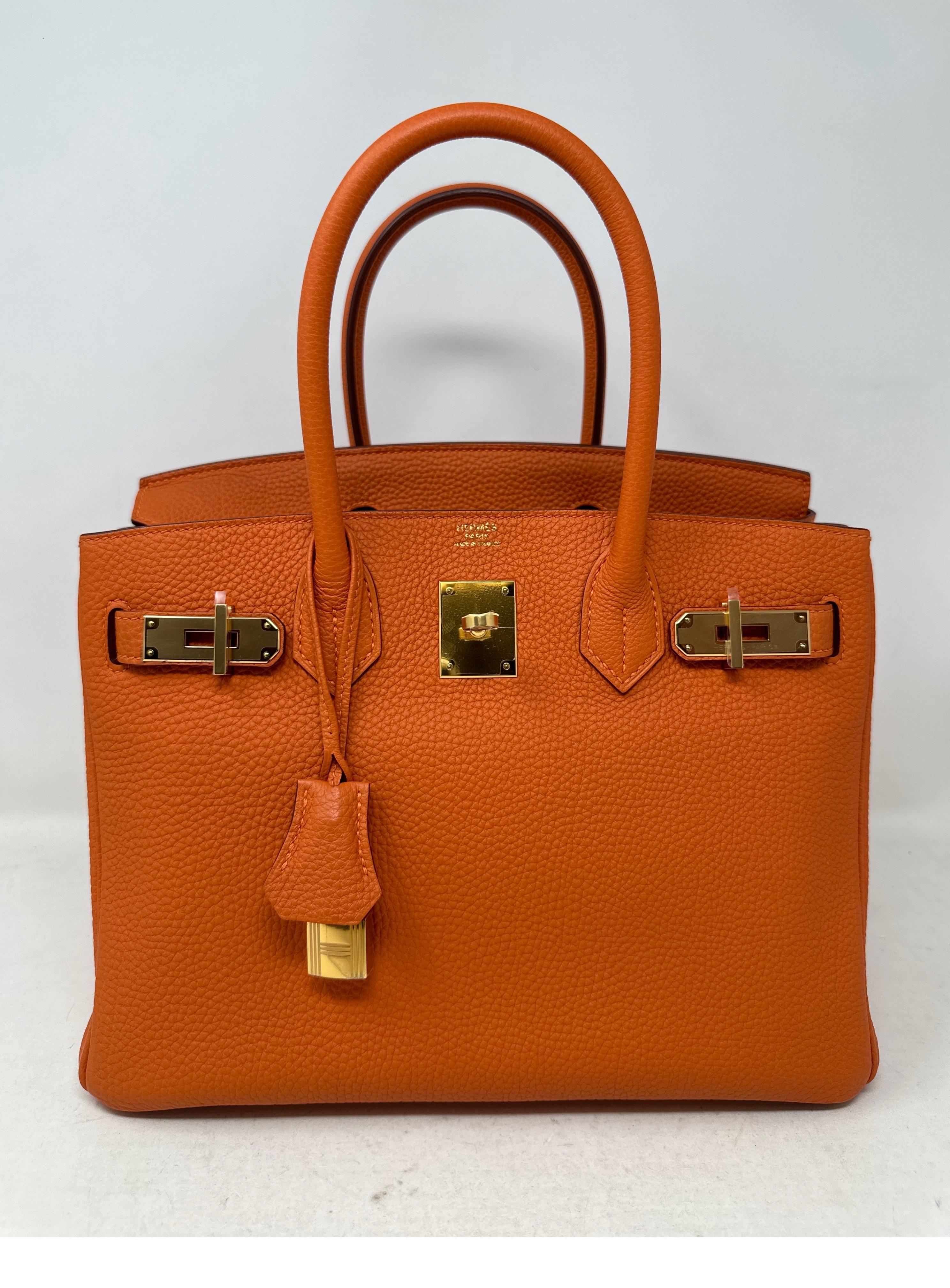 Hermes Orange Birkin 30 Bag. Most classic orange Hermes color. This bag looks like it was never used. Excellent condition. Gold hardware. Togo leather. Stunning combination. Perfect gift to an Hermes  collector. Includes clochette, lock, keys, and
