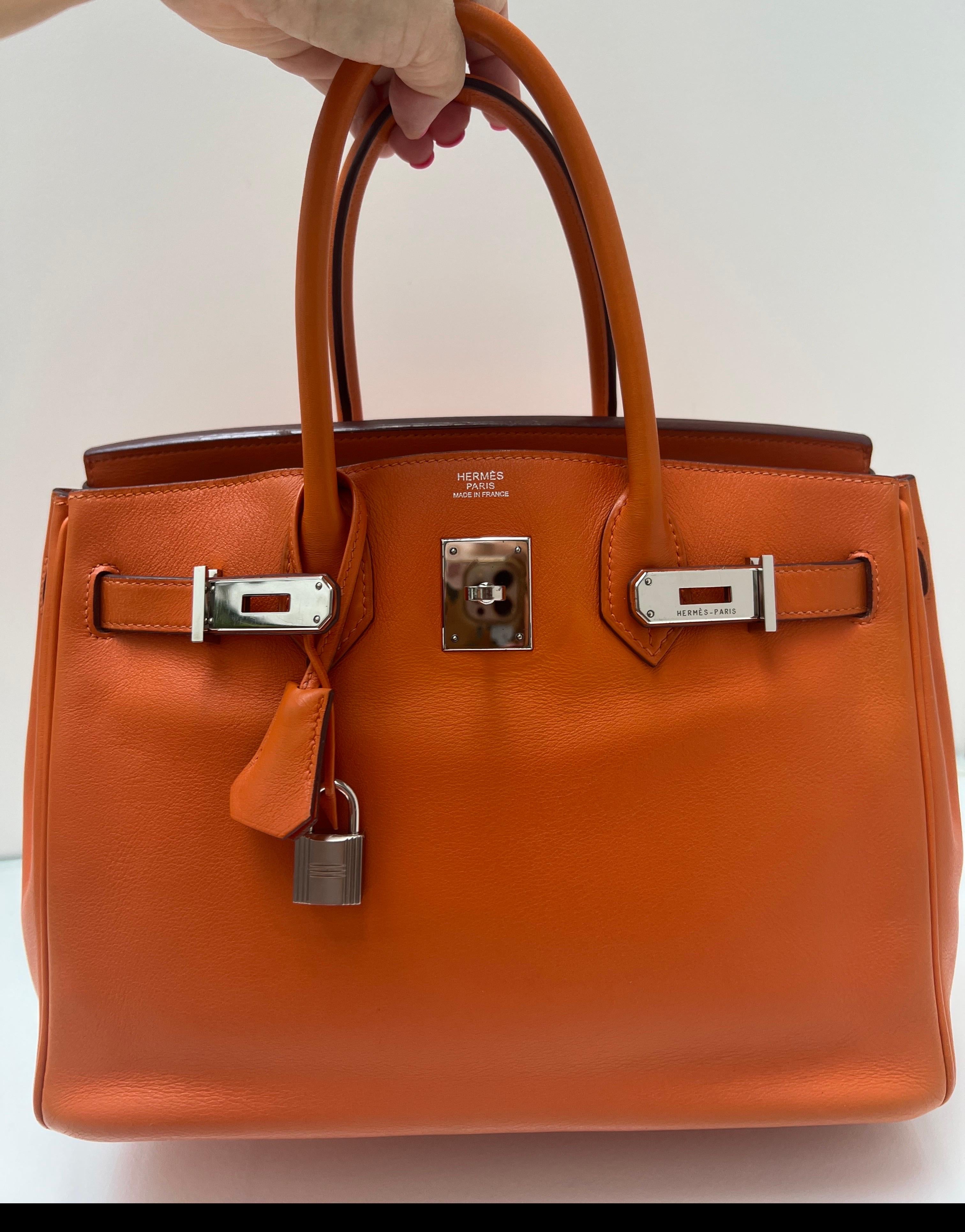 Borsa Birkin 30 arancione di Hermes. Pelle liscia e veloce. Hardware in argento palladio. Buone condizioni. Interni puliti. Classico colore arancione per Hermes. Prezzo di vendita. Include clochette, lucchetto, chiavi e sacchetto antipolvere.