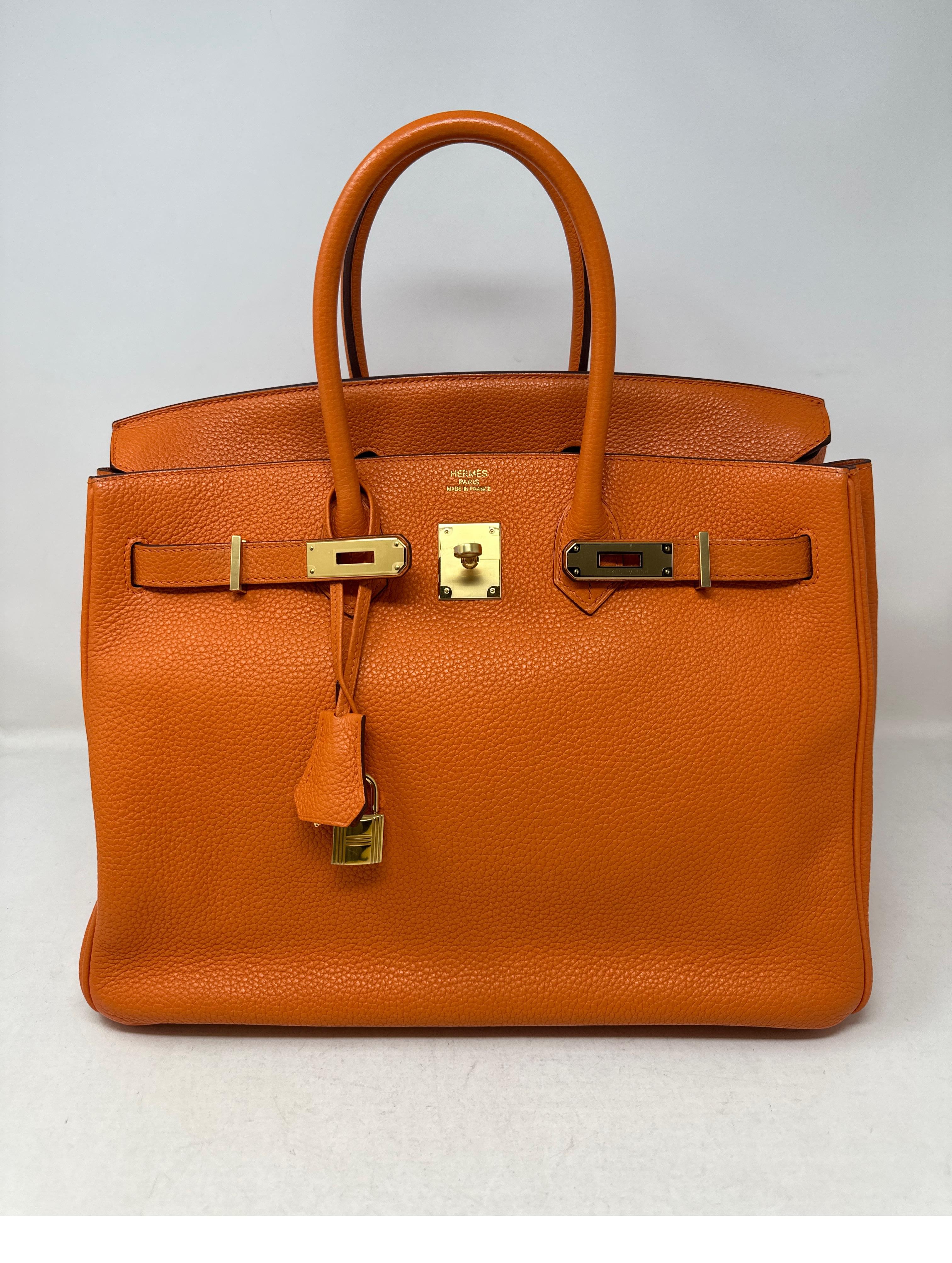 Hermes Orange Birkin 35 Bag. Togo leather. Classic orange color. Gold hardware. Interior clean. Plastic still on hardware. Includes clochette, lock, keys, and dust bag. Guaranteed authentic. 