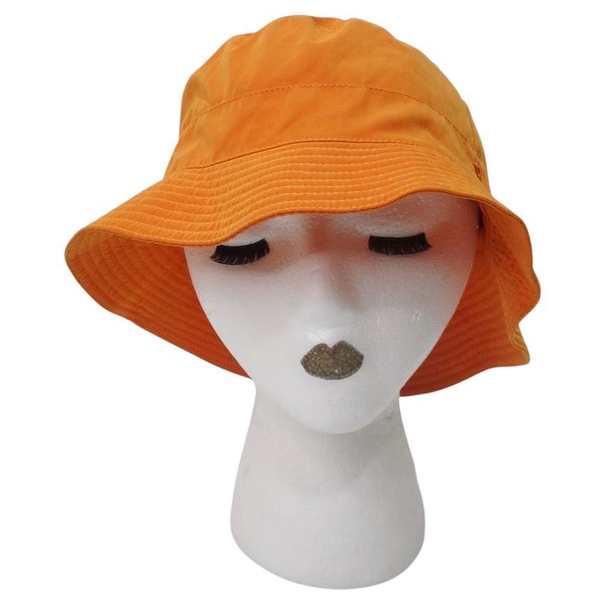 Super amusant chapeau seau orange Hermès ! Dans une magnifique couleur orange/jaune embrassée par le soleil, faite d'un polyester léger qui se drape sans effort. Le style est presque un croisement entre un seau et une capeline, car vous pouvez