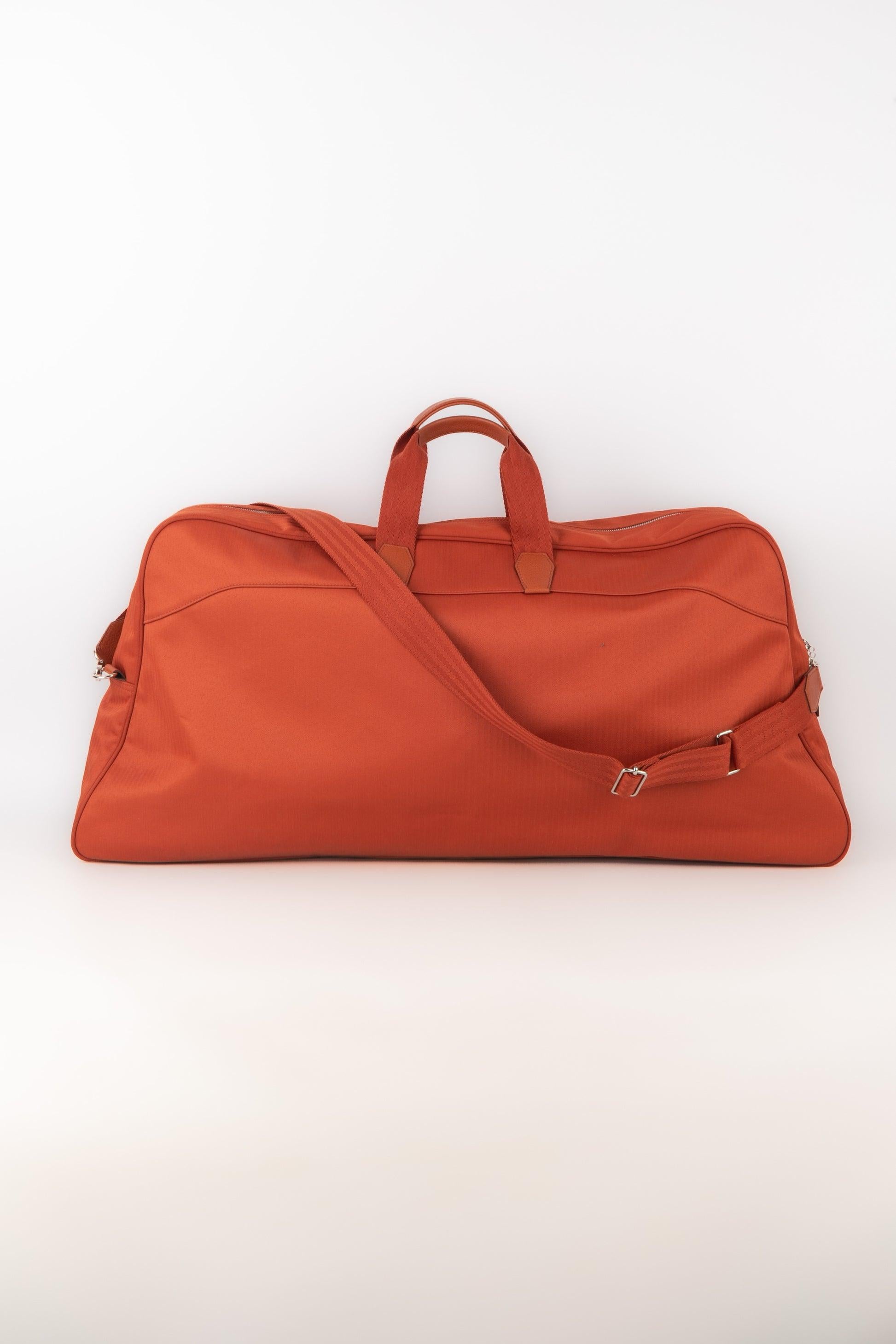 Hermès - Orange canvas tennis bag, racket pocket on the front, and natural leather elements. Removable handle, silvery metal padlock with two keys, and two storage cover with towels.

Additional information:
Condition: Very good