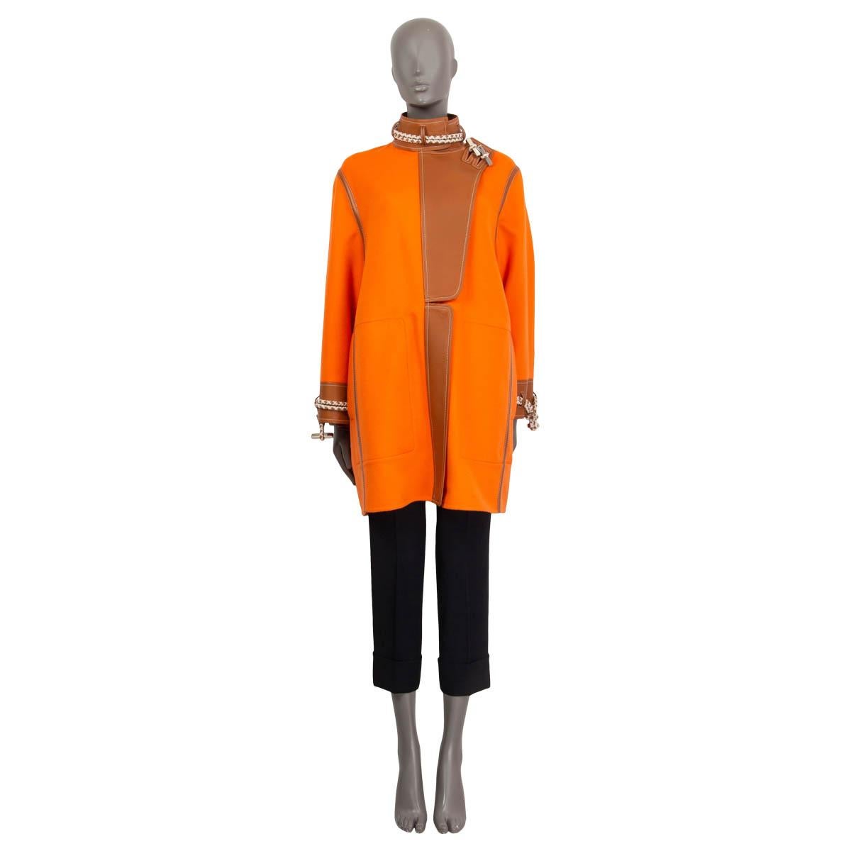 100% authentic Hermès Spring/Summer 2019 cashmere coat in orange and camel cashmere (100%). Features cord and lambskin leather (100%) embellishments at the neck, the trim and the cuffs. Opens with two toggles, a concealed zipper and three push