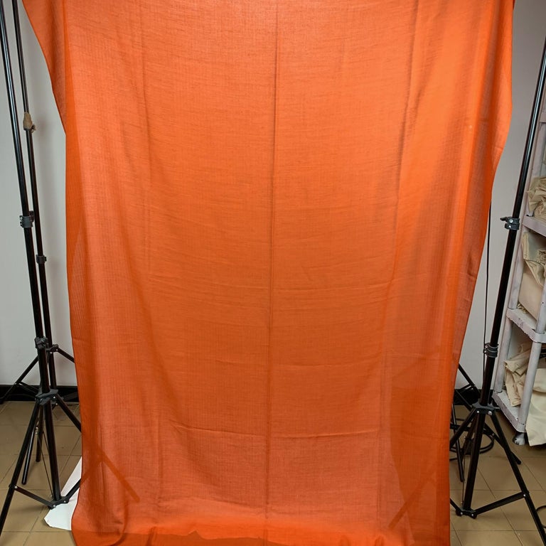 Rare cashmere and wool scarf by Hermes. Orange color. Big H pattern in the center. Composition; 80% Cashmere,20% Wool. Fringed hem. Approx. measurements: 60 x 80 inches - 152 x 203. Made in Italy. 'HERMES - Paris' and composition tags are still