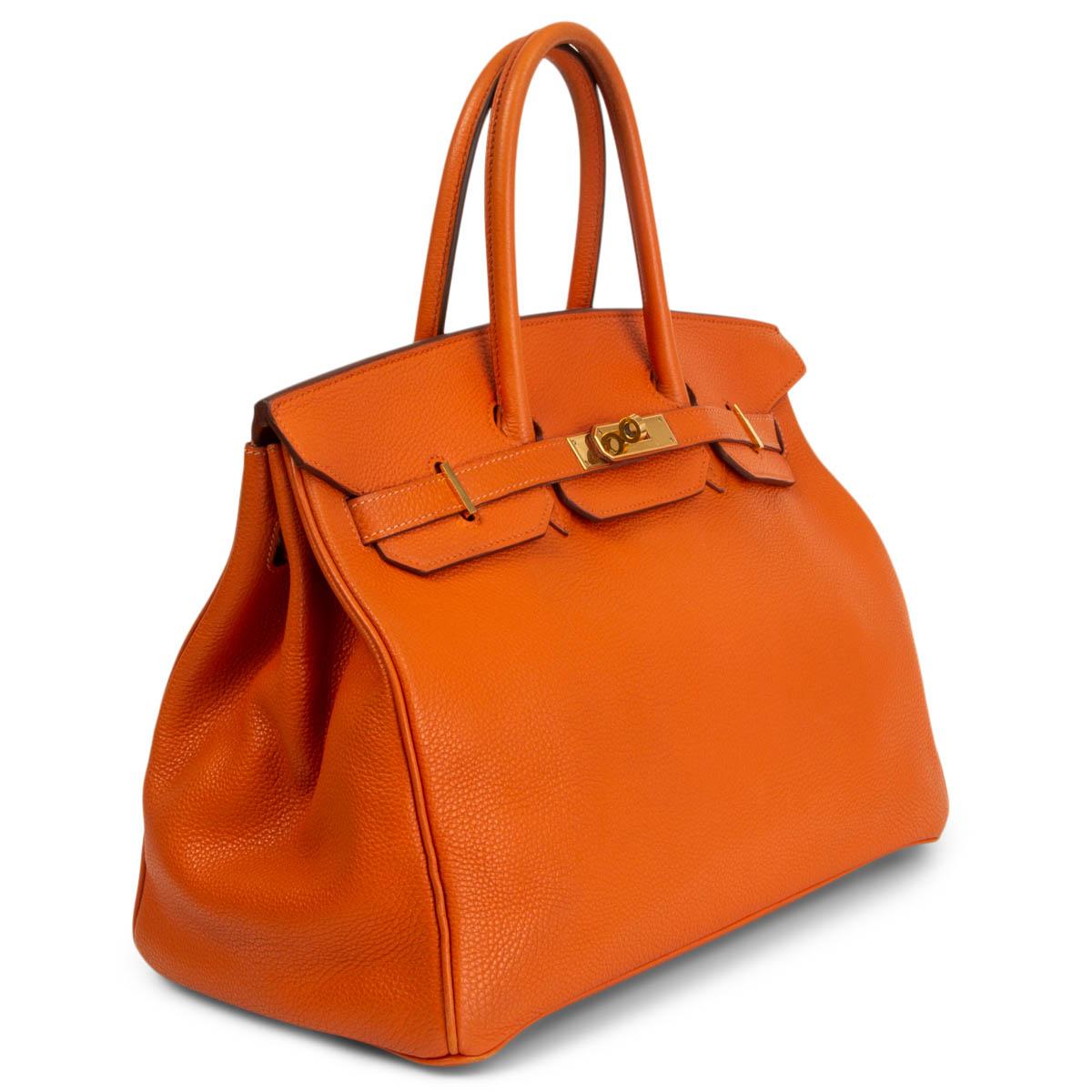 100% authentic Hermès 35 Birkin in orange soft Taurillone Clemence leather. Lined in Chèvre (goat skin) with an open pocket against the front and a zipper pocket against the back. Has been carried with some wear to the corners and handles. Overall
