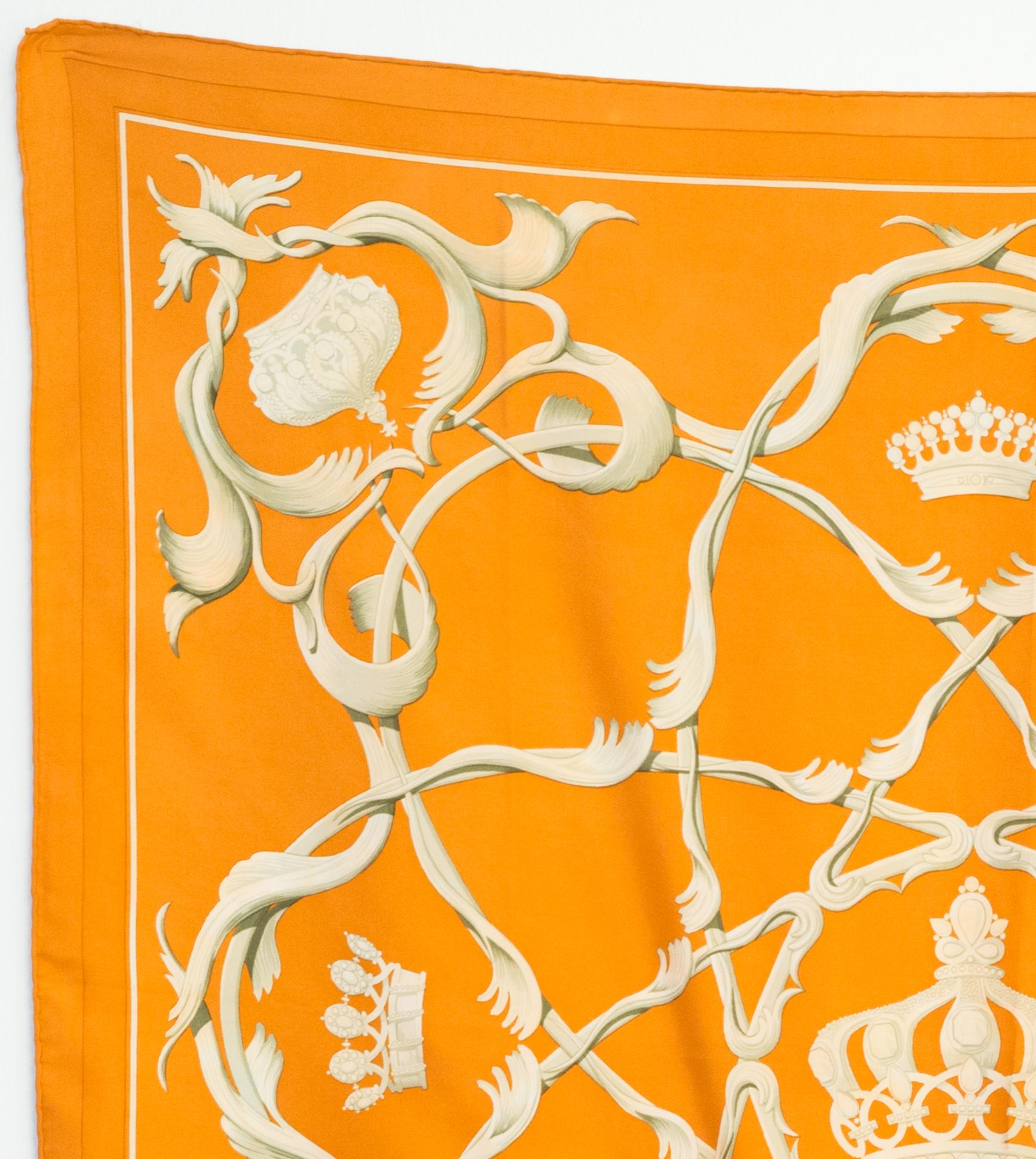 Hermes silk scarf Crowns by by Julia Abadie featuring an orange ground with crowns on and a Hermès signature. 
First issue 1969
In good vintage condition. Made in France.
35,4in. (90cm)  X 35,4in. (90cm)
We guarantee you will receive this  iconic
