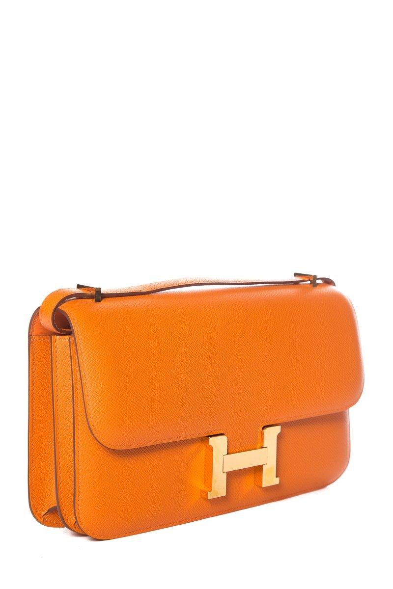 Hermes orange Epsom leather Constance with gold-plated hardware, single convertible shoulder strap, tonal leather lining, dual compartments, dual pockets at interior, and 'H' push-lock closure at front. Includes dust cover and box.
This item is in