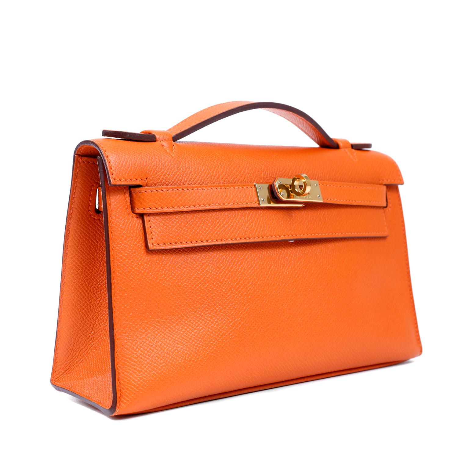 This authentic Hermès Orange Epsom Kelly Pochette is in pristine condition. A clutch version of the classic Kelly, it has a stable base allowing it to stand upright and easily carries all the essentials for an evening.
Epsom leather is textured and