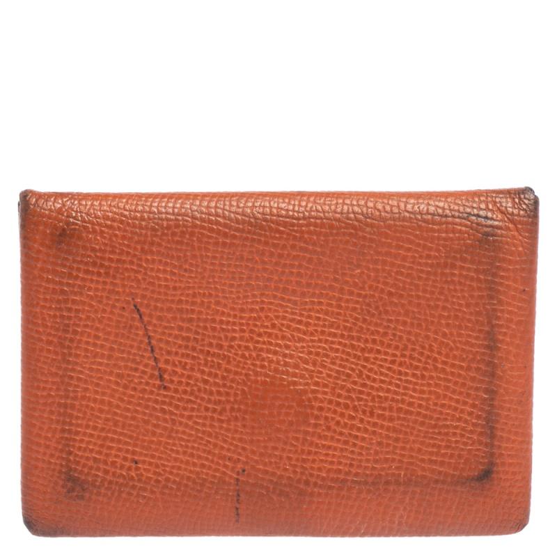 Add a touch of minimized elegance when you style this Hermès Calvi card holder with your favorite accessories. Much coveted amongst contemporary fashionistas, this cardholder has a simple silhouette and is secured with a snap button fastening. It is