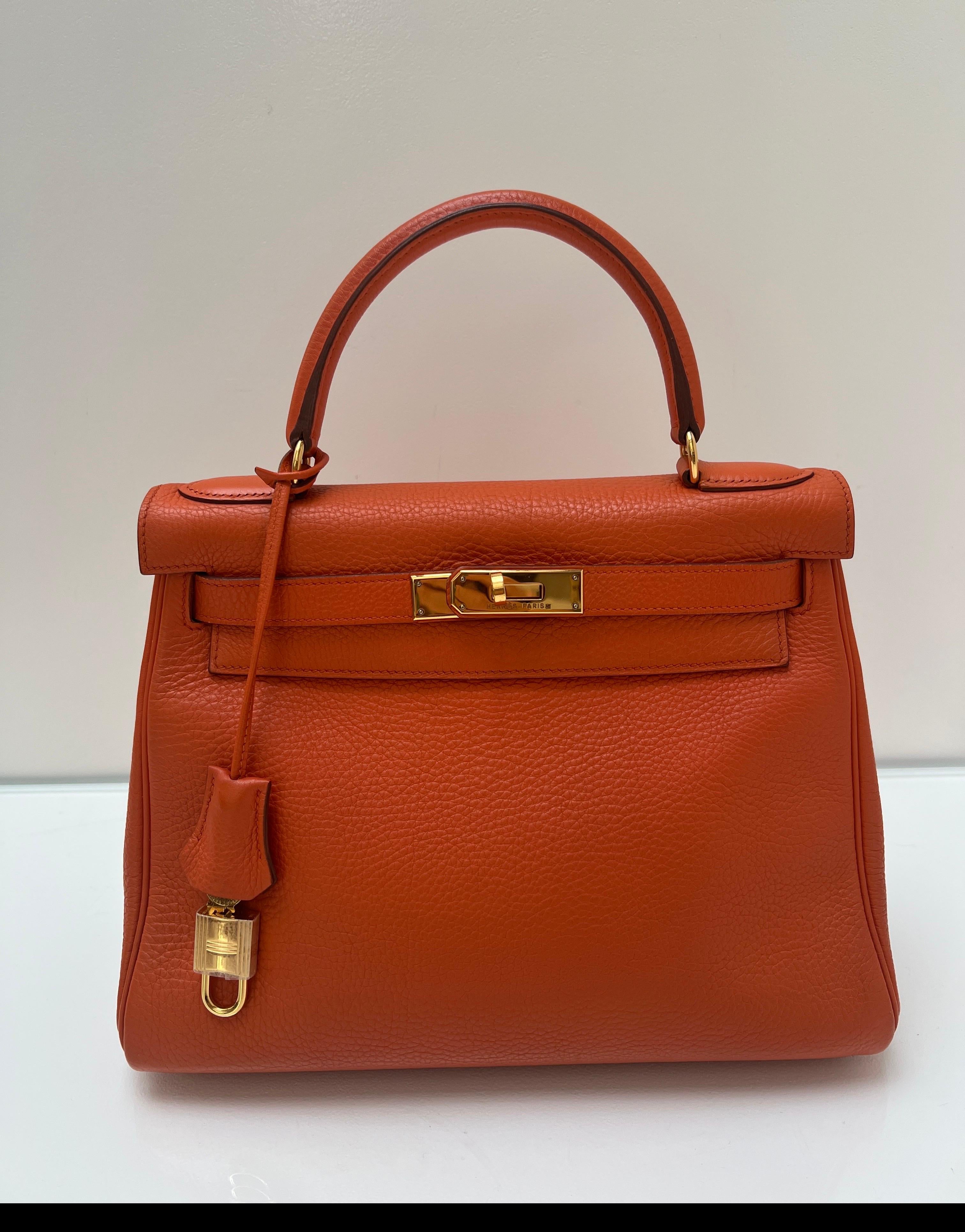Borsa Kelly 28 arancione di Hermes. Condizioni eccellenti. Ferramenta dorata. Pelle di Togo. Interni puliti. La dimensione più desiderata e difficile da trovare. Include clochette, lucchetto, chiavi e sacchetto antipolvere. Garanzia di autenticità. 
