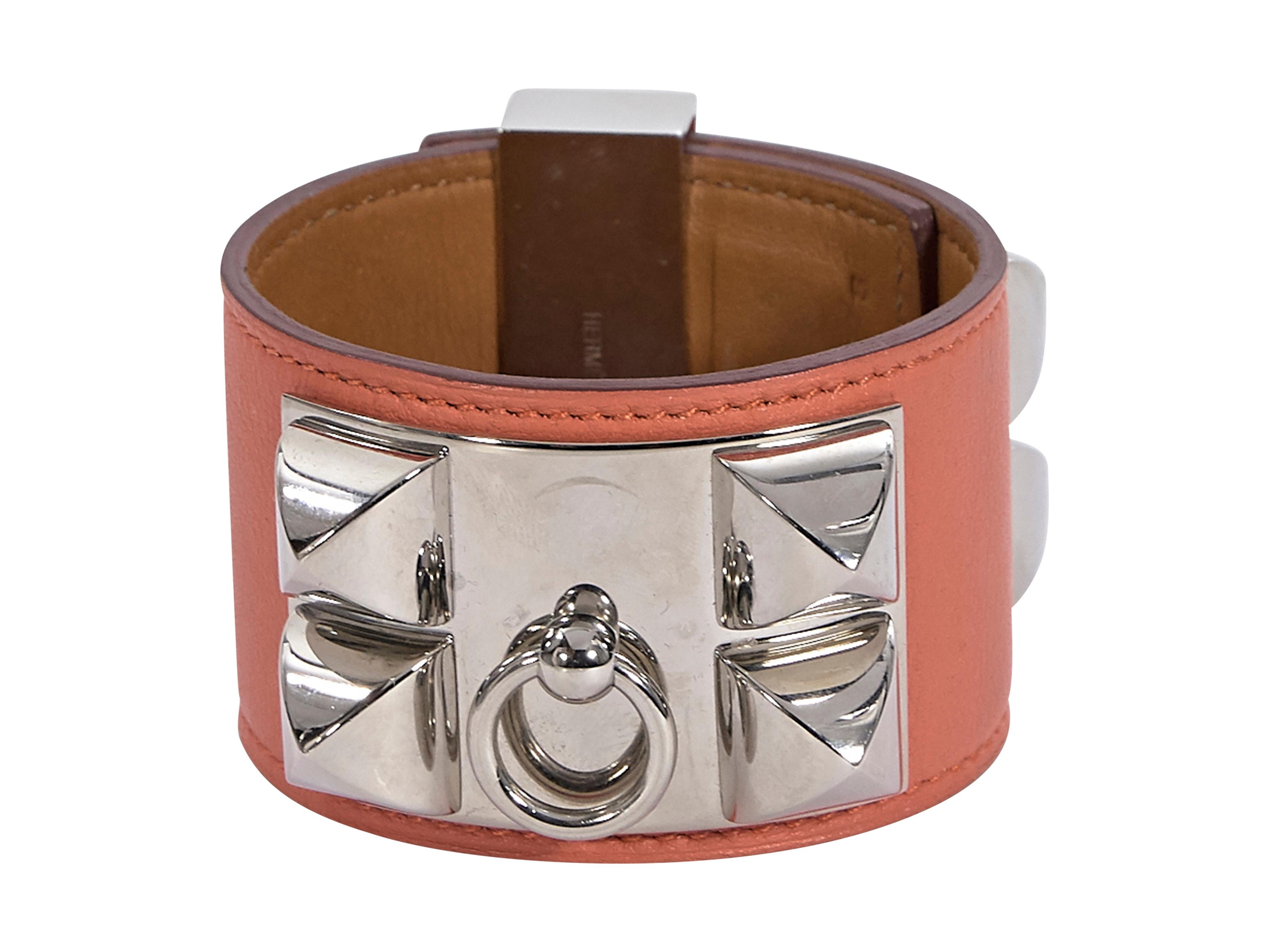 Product details:  Orange leather Collier de Chien bracelet by Hermes.  Twist-lock closure.  Slivertone hardware.  8.25