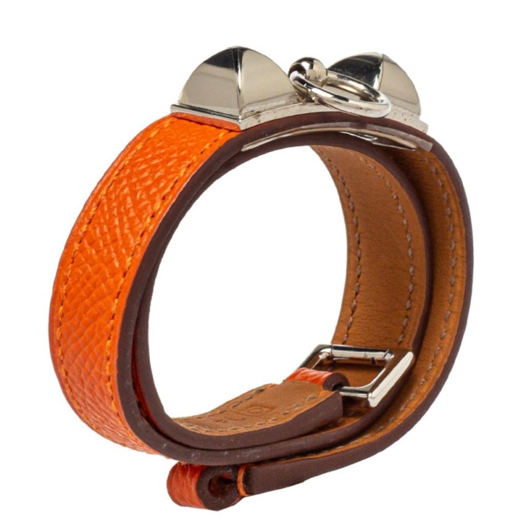 This Hermès Double Tour bracelet is a chic accessory that can be paired with everything, from casuals to evening outfits. Made from leather, it is beautified with pyramid studs and a ring in palladium-plated metal. The orange bracelet has a long