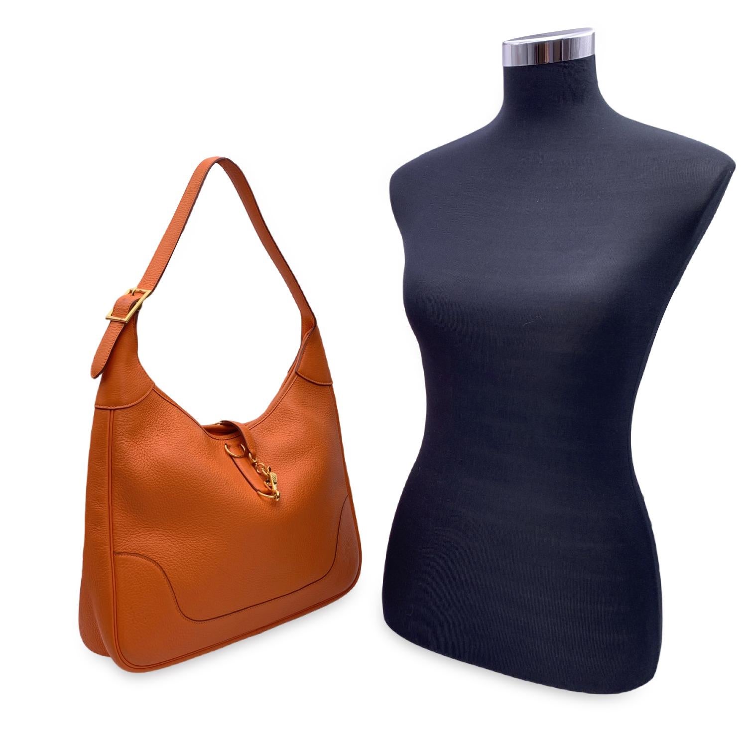 This beautiful Bag will come with a Certificate of Authenticity provided by Entrupy. The certificate will be provided at no further cost.

Super-chic Hermes 'Trim II 35' hobo bag in orange leather. It features an adjustable looping shoulder strap