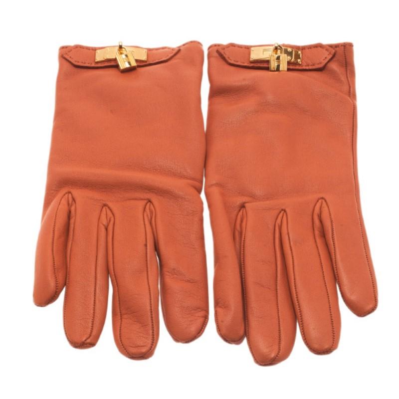Colored with the signature Hermes orange, this pair of gloves will give you the class of Jackie O. Their leather exterior is coupled with golden padlock detailing at the ends of the gloves for another touch of Hermes' signature.

Includes: The