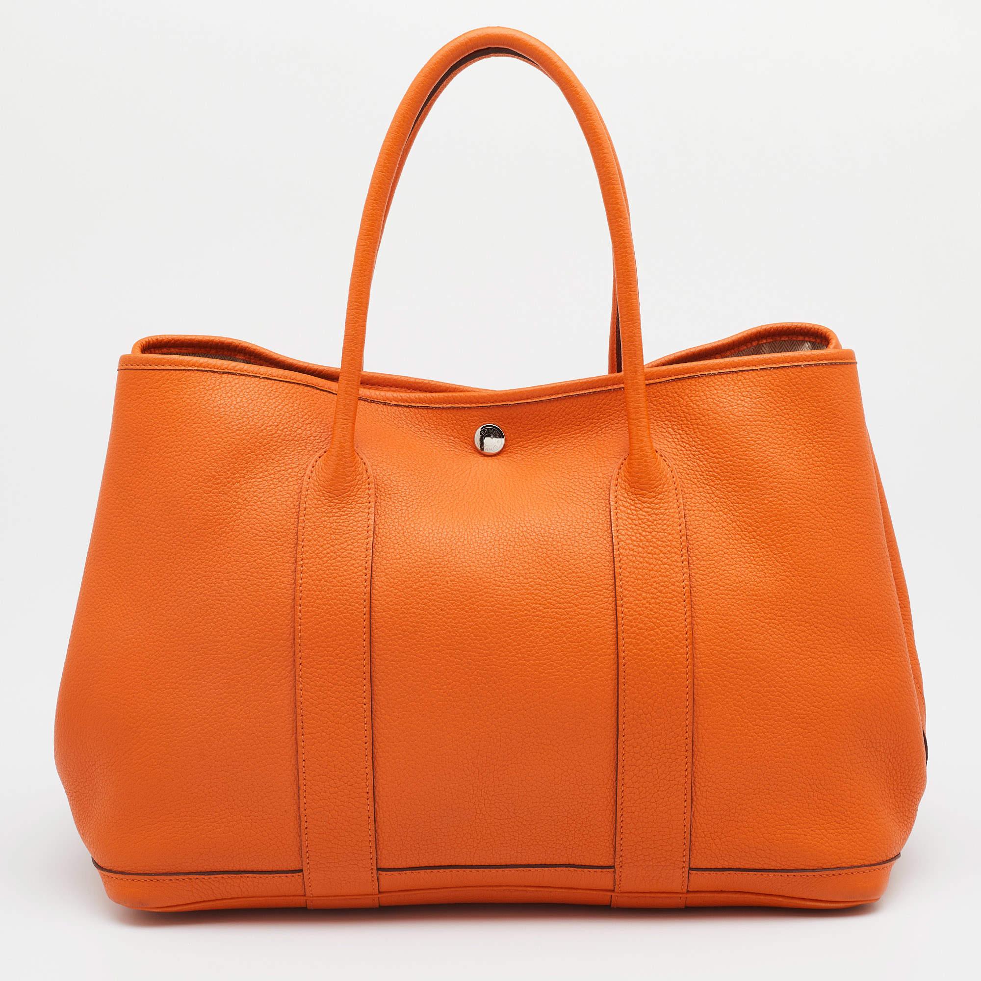 Crafted into an eye-catchy silhouette and style, this Garden Party 36 tote from Hermes exudes just the right amount of charm and elegance! It is made from Orange Negonda leather, with a closure detail highlighting the front. It has a spacious