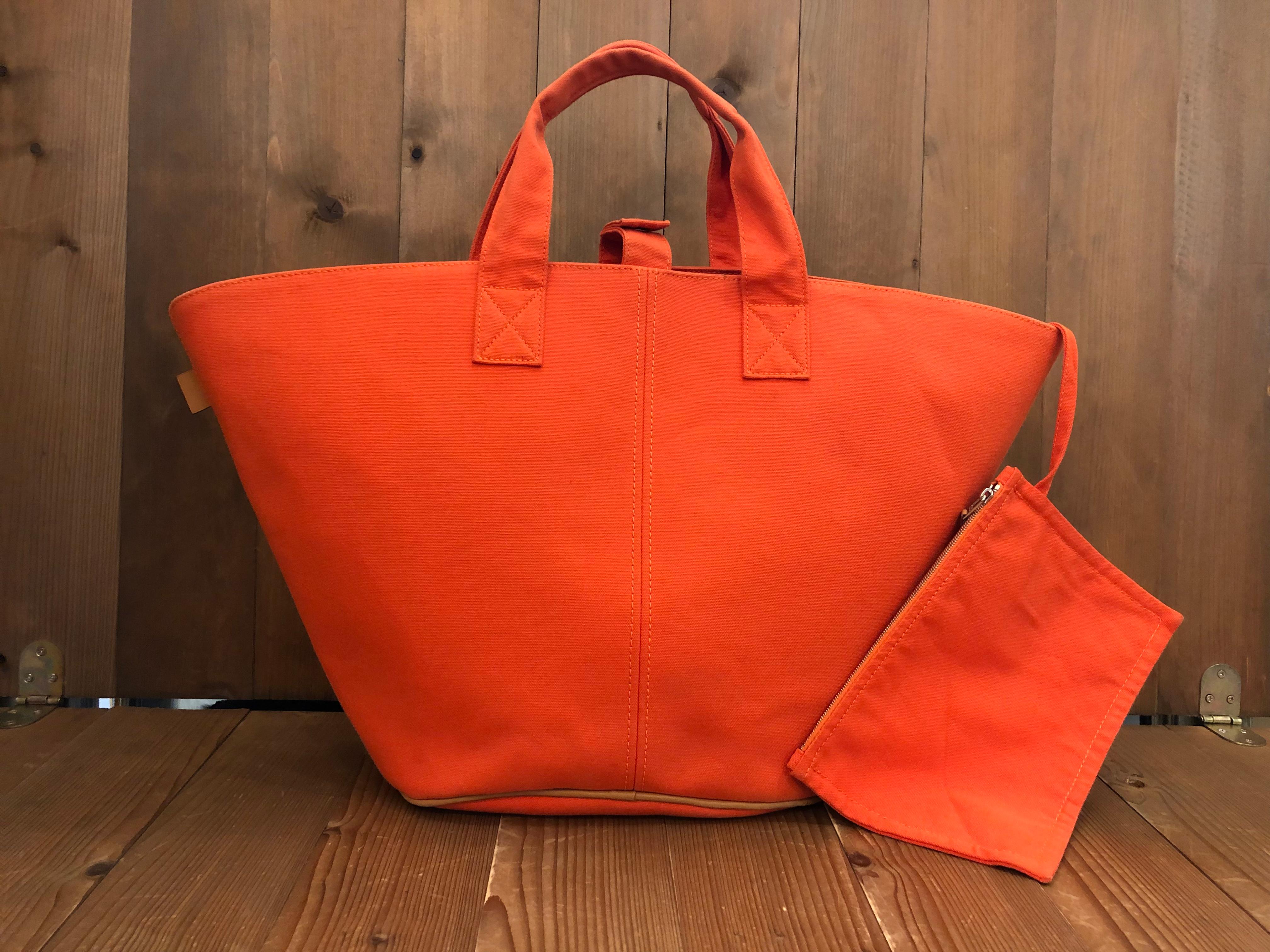 HERMES Pannied Platouge PM tote bag in vivid orange colored cotton trimmed with leather and silver hardware. This Hermes tote features a wide opening with snap fastening closure for easy access to your belongings and a pouch with zipper closure of