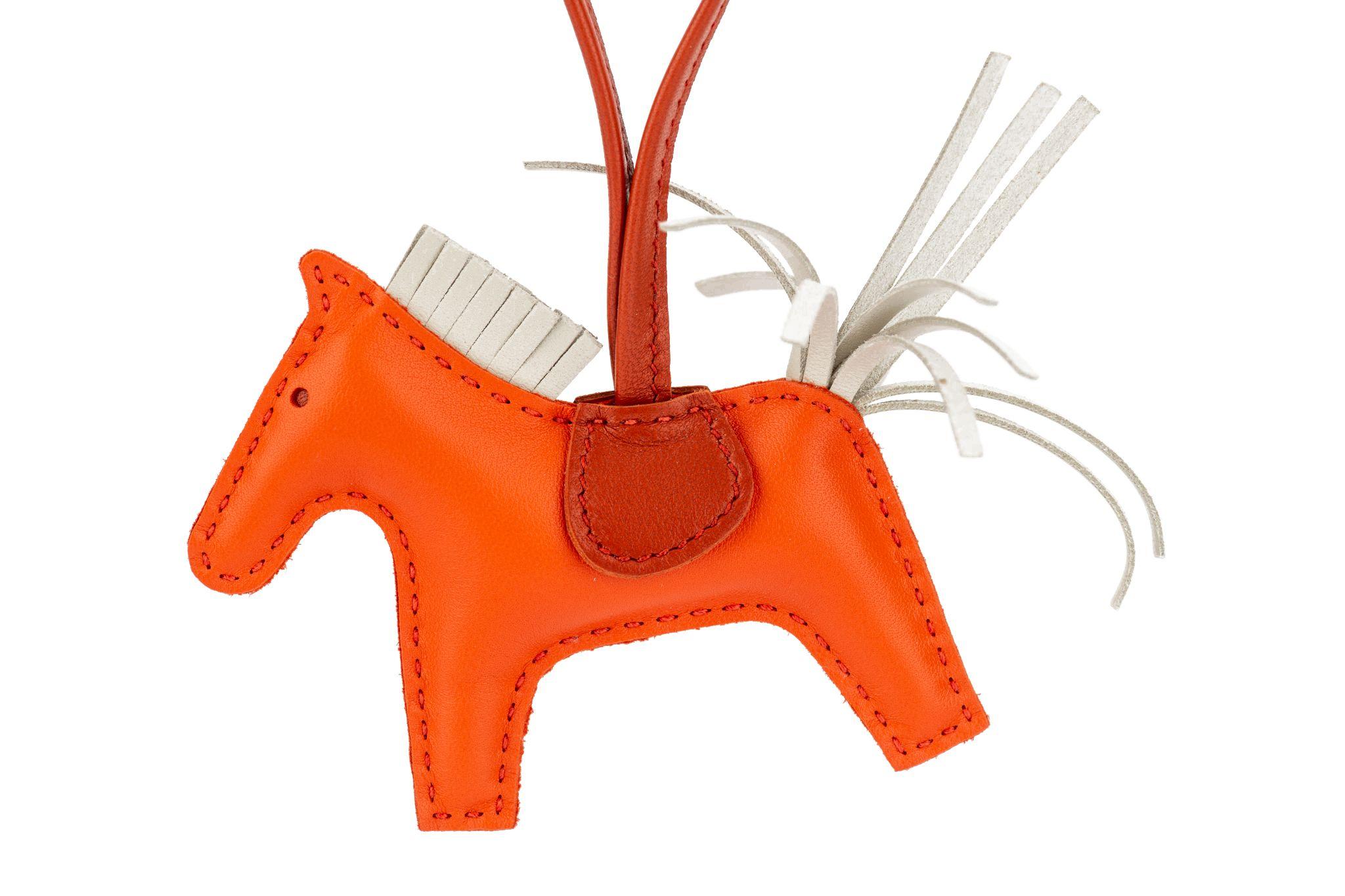 Hermès grigri rodeo bag charm. Size: PM (small). Brand new. Combination of orange, poppy, nata leather. Comes with box, ribbon. Marked: Hermés Paris Made in France.