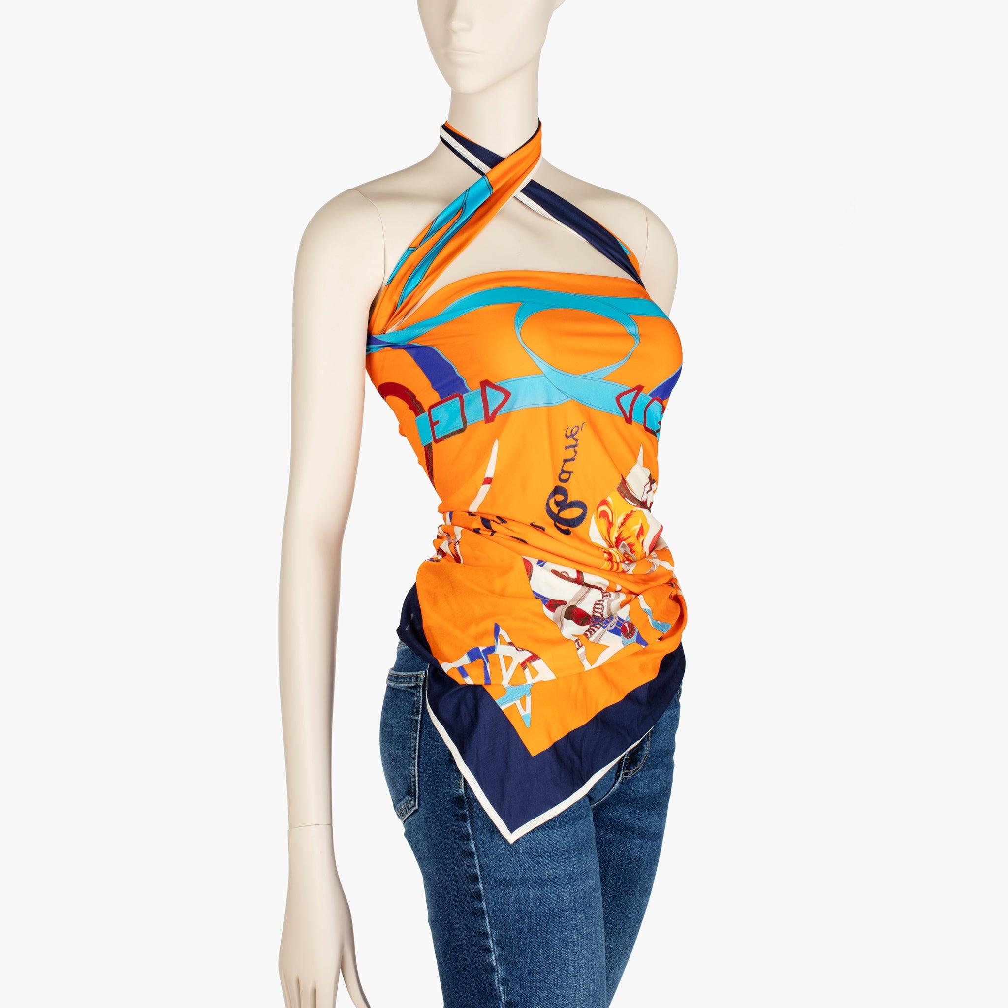 Elevate your summer styling with this vibrant Hermès silk scarf, creatively worn as a top. Rendered in a striking orange palette with contrasting navy and turquoise, the print celebrates the maison’s equestrian heritage with bridle and harness