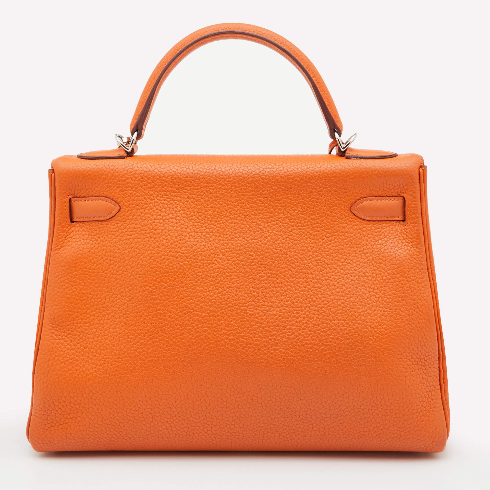 The Kelly is known for its simple design and unmatched elegance. This authentic Kelly Retourne 32 is rendered in orange Taurillion Clemence leather and has palladium-finished fittings. The top handle and detachable shoulder strap allow multiple