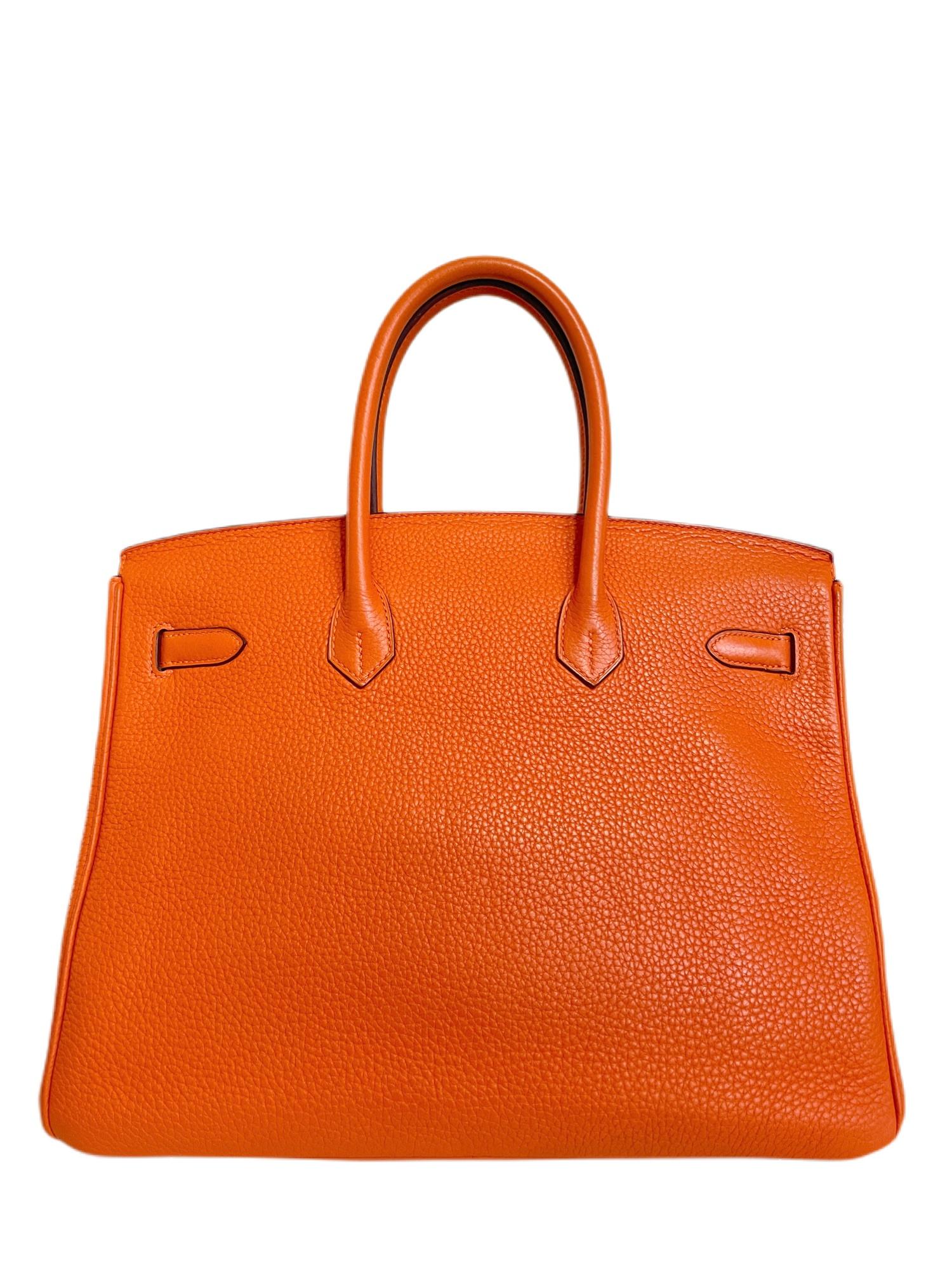 This authentic Hermès Orange Togo 35 cm Birkin is in pristine condition.  Orange with Palladium is the ultimate pop of color and is remarkably wearable year-round.  
Togo is durable and textured; the most popular leather choice for the Birkin. 