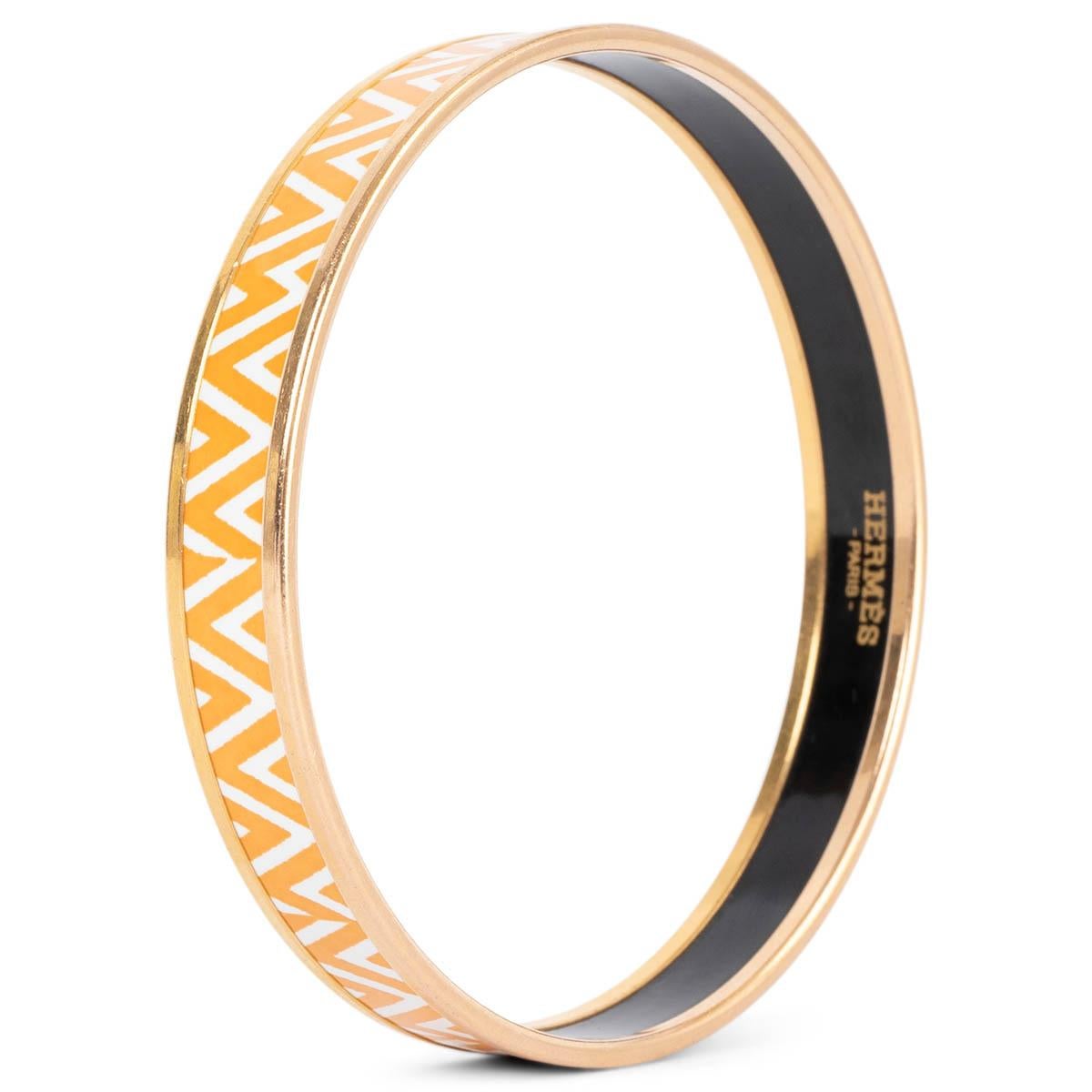 100% autentico braccialetto Hermès Zigzag stretto in smalto arancione e bianco. È stato indossato ed è in ottime condizioni. 

Misure
Dimensioni dell'etichetta	65
Larghezza	1cm (0.4in)
Circonferenza	21cm (8.2in)
Hardware	Oro

Tutte le nostre
