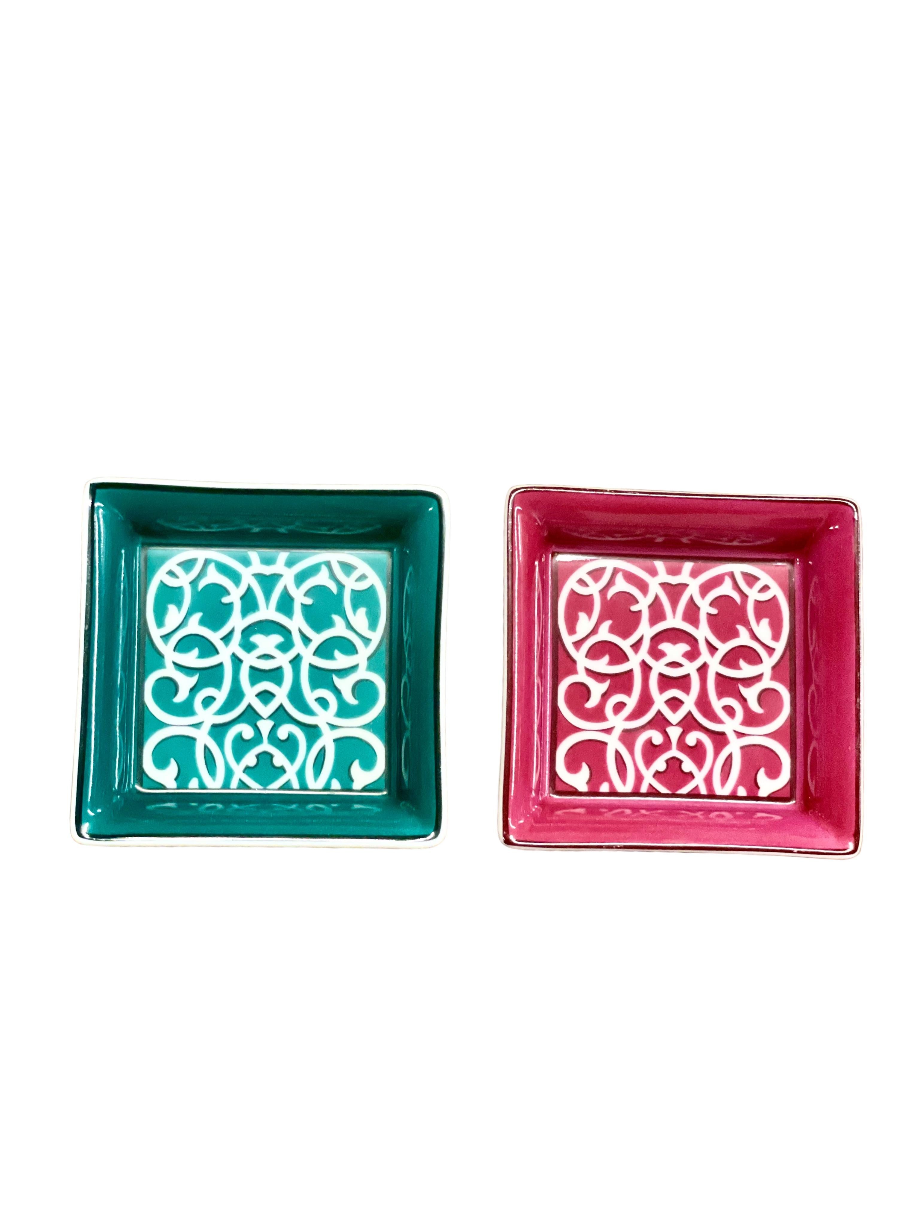 A striking pair of Hermès porcelain trinket or cufflink trays, one pink and one green, with intricate geometric detailing on each, and matching velvet color on each of the bottom trinket. 