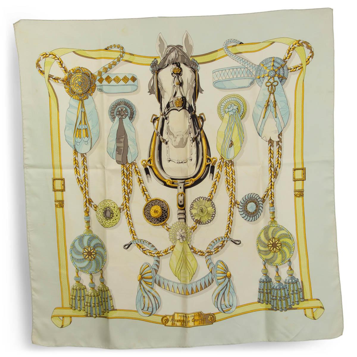 100% authentic Hermès 'Frontaux Et Cocardes 90' scarf by Caty Latham in ivory silk twill (100%) with pale teal border and details in gold, yellow and gray. Has been worn with stains through out. Overall in good vintage