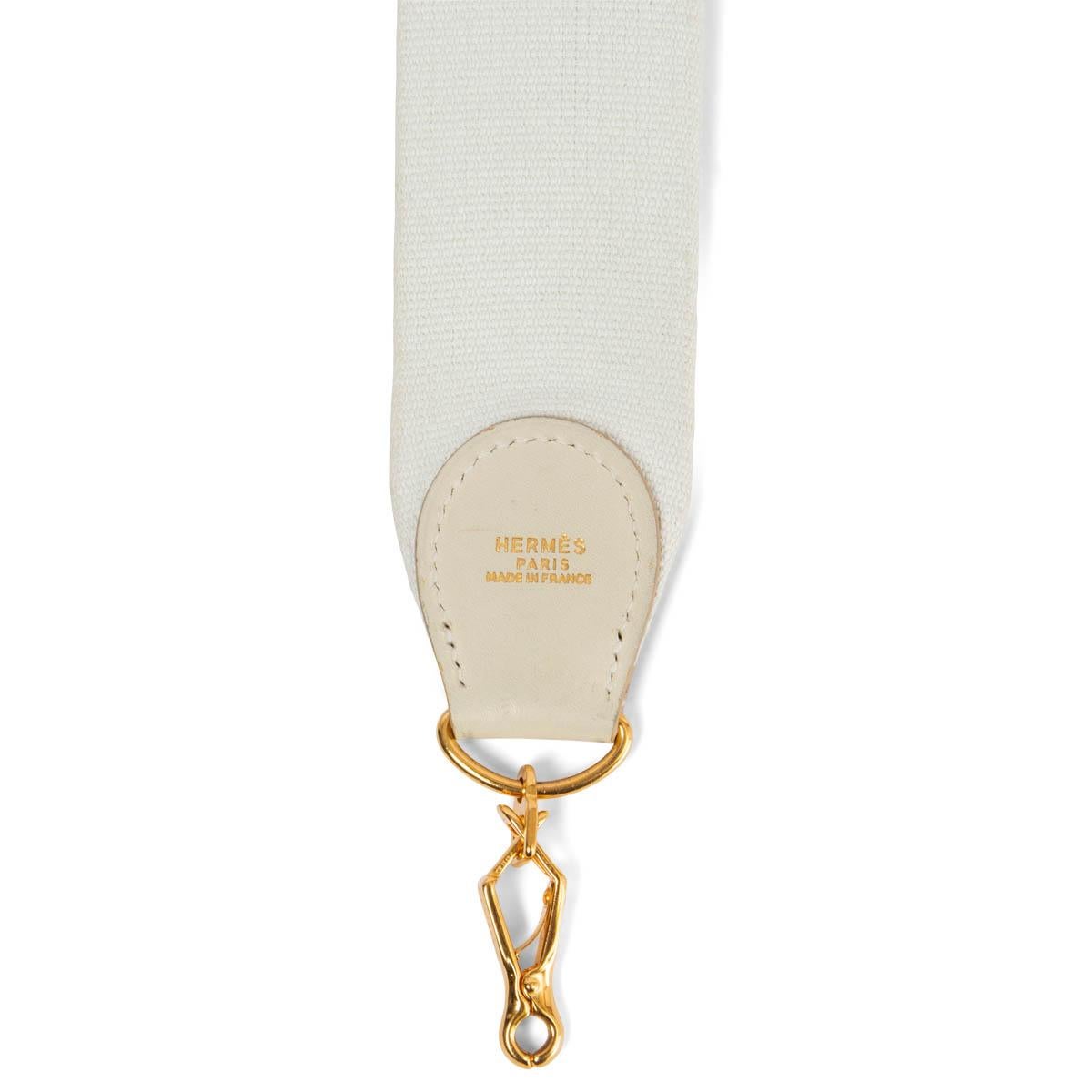 100% authentic Hermès shoulder strap for your Kelly or Evelyne bag in white canvas and Parchemin (ivory) leather. Has been carried and and shows some soft wear to the leather parts and on the edge of the canvas. Overall in very good