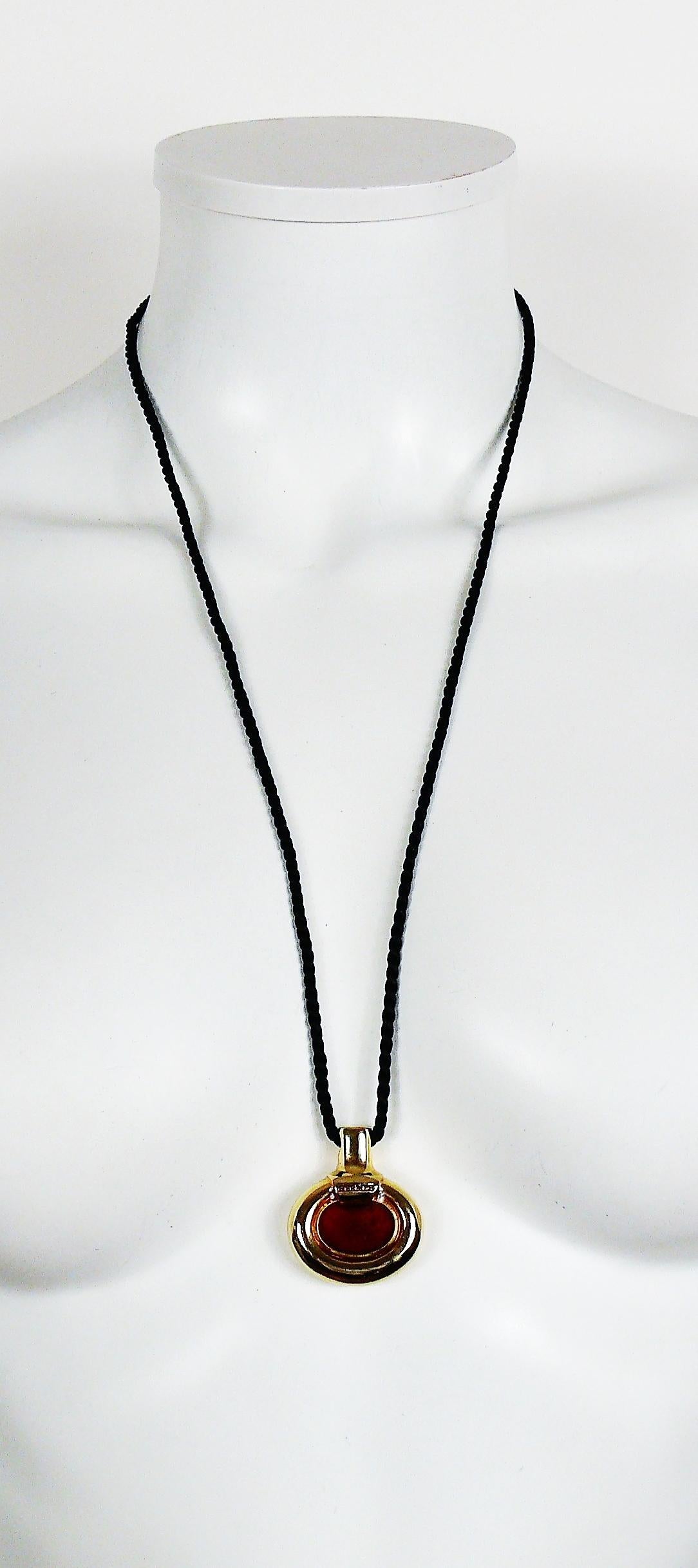 HERMES Parfums vintage, collier cordon noir avec pendentif en forme de flacon de parfum en métal doré et émail rouge.

Système de diffusion de parfum (plus d'odeur).

Embossé HERMES.
Au verso, PARFUM D'HERMES PARIS est embossé.

Référence : BIJOUX