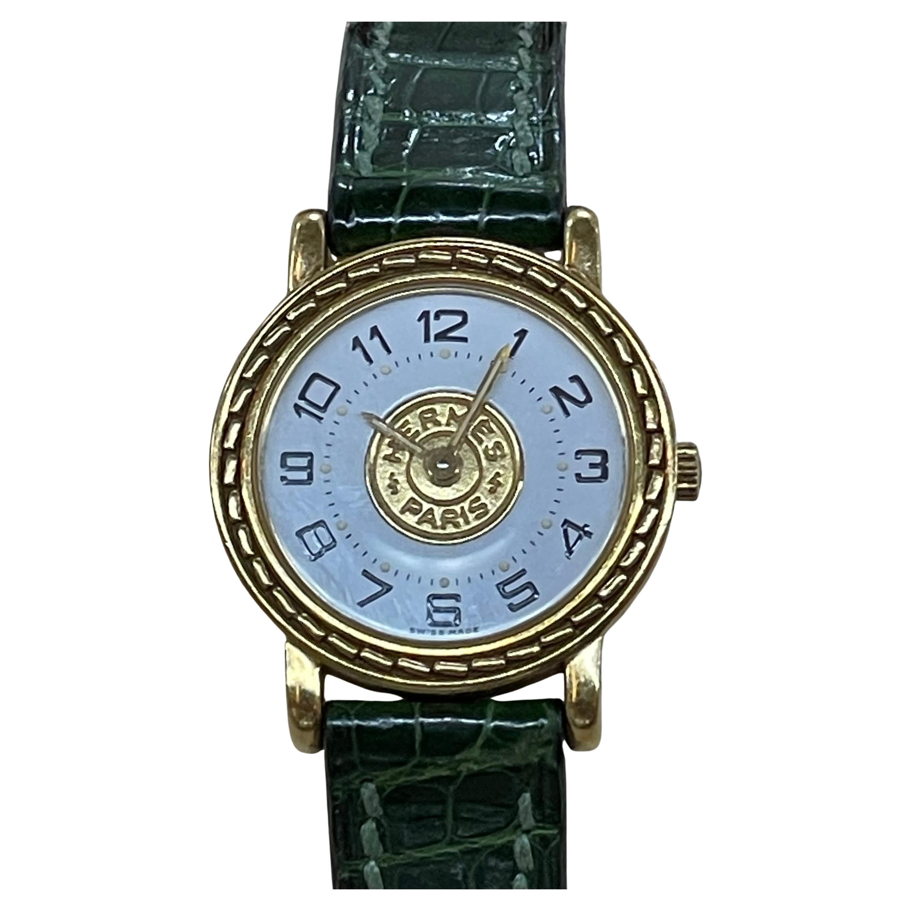 Hermès Paris 18 Kt Gold 'Sellier' Wristwatch, Crocodile Strap

18 kt., quartz, circular white dial, center gold-tone and outer decorative gold bezel, black Arabic numerals, luminous dots and hands, logo crown, dia. ap. 24 mm., green