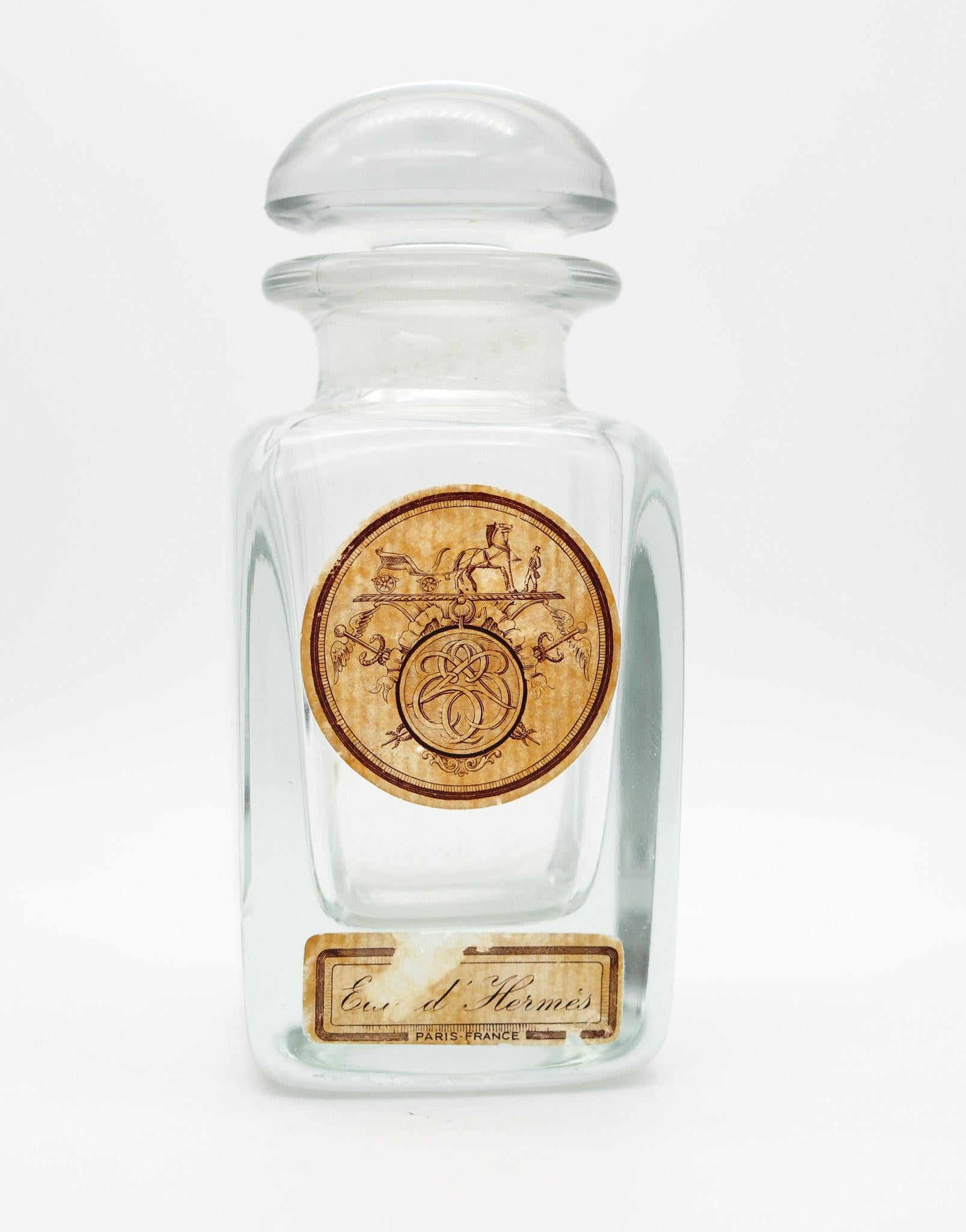 Flacon de parfum vintage de la marque Hermes.

Très beau flacon d'Eau d'Hermes, fabriqué à Paris par la maison de couture Hermes, dans les années 1950. Ce grand flacon a été réalisé en cristal transparent pressé, très épais et audacieux, et est