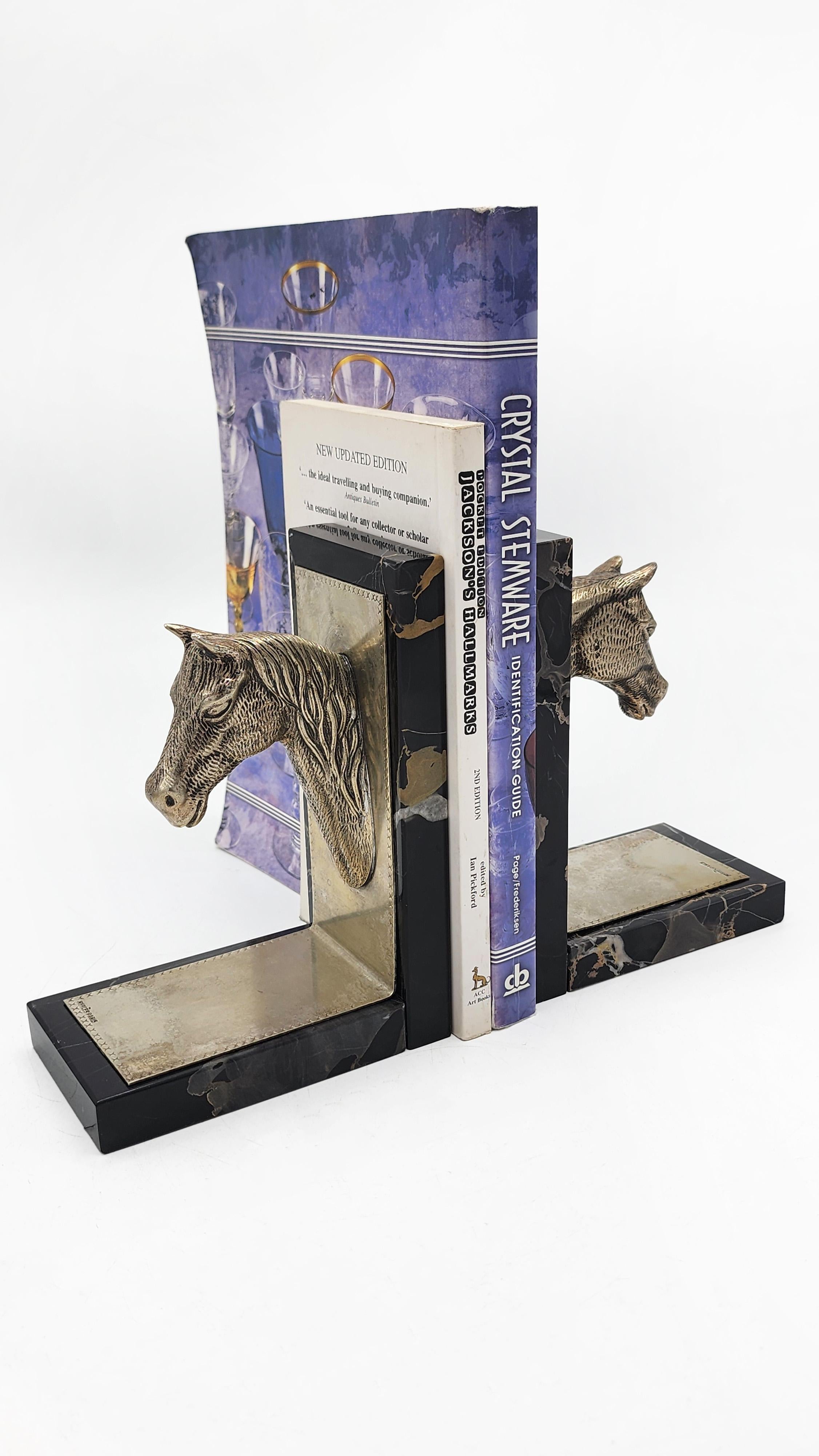 Reggilibri Hermes Paris Art Deco con testa di cavallo
Si tratta di una coppia di fermalibri in stile Art Déco con una testa di cavallo scolpita in bronzo. Ogni testa è montata su una base rettangolare in marmo scuro con dettagli intarsiati in una