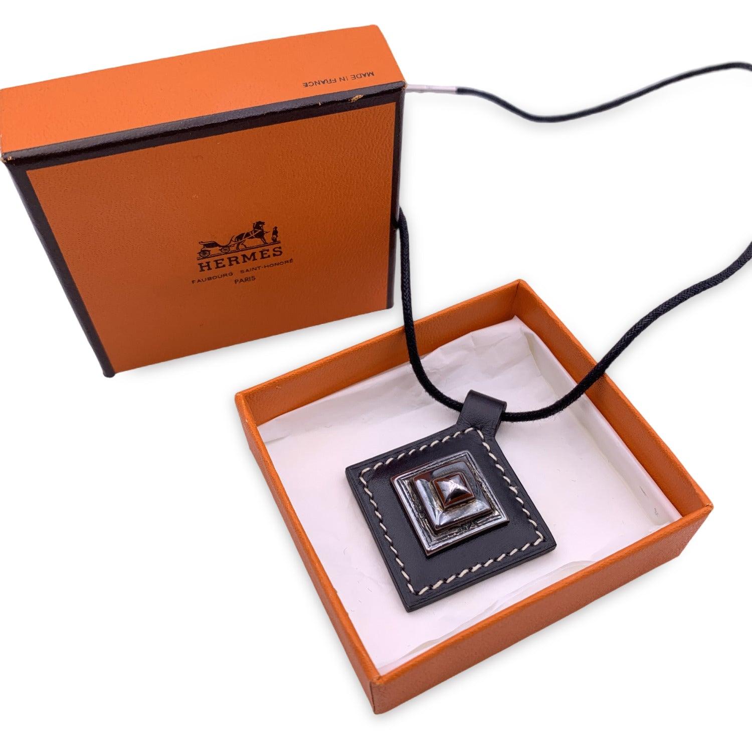 Beautiful rolle leather necklace 'Tuareg' by Hermes. Elegant black leather diamond shaped pendant with sterling silver piece. Turn lock closure. 'Hermes' engraved on the reverse of the necklace. Blind stamp is 'F' encased in a square (year of