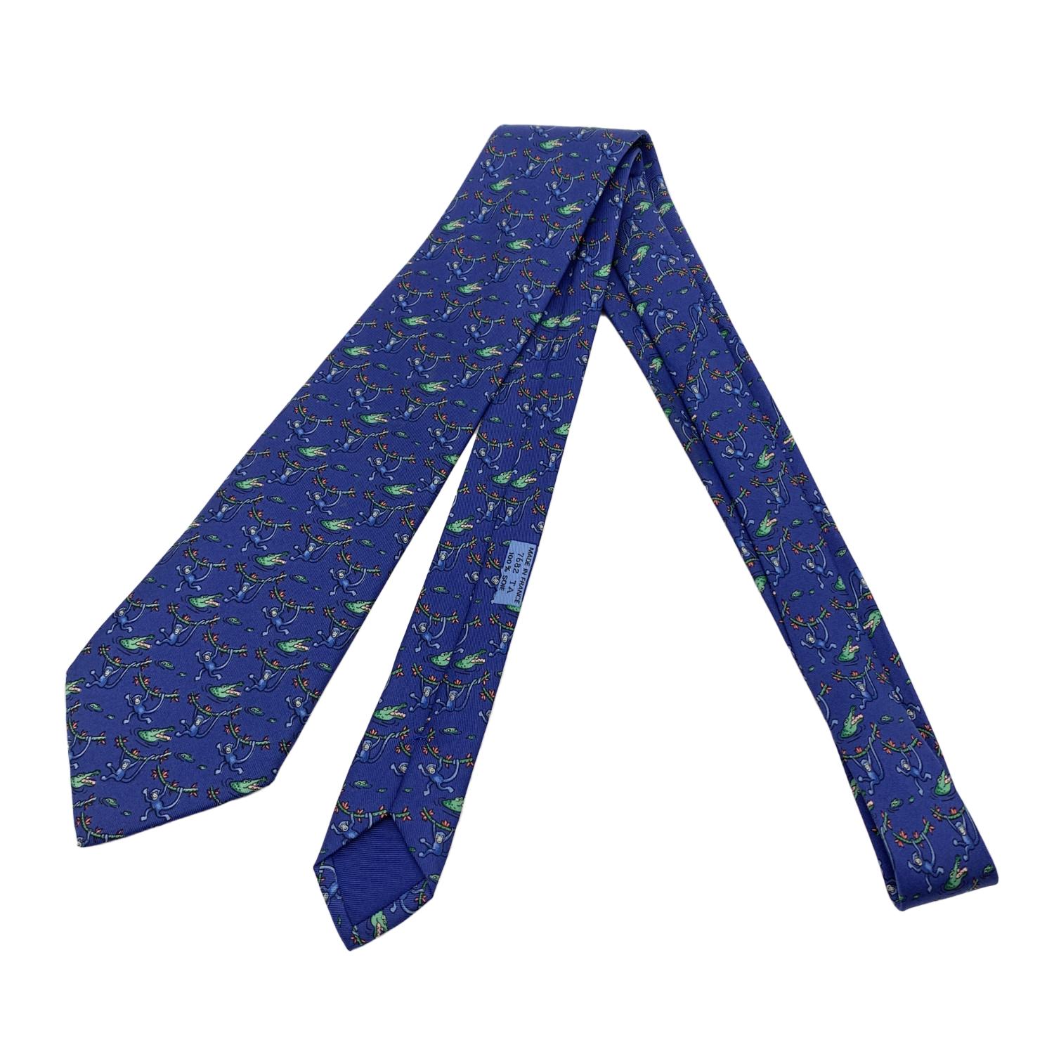 Elegant Hermes Neck Tie, 7682 TA, with crocodile and monkey print on blue background. Composition: 100% Silk. Hermes composition tag attached. 'HERMES Paris' with copyright symbol printed on the back. Made in France. Total length:58 inches - 147.4