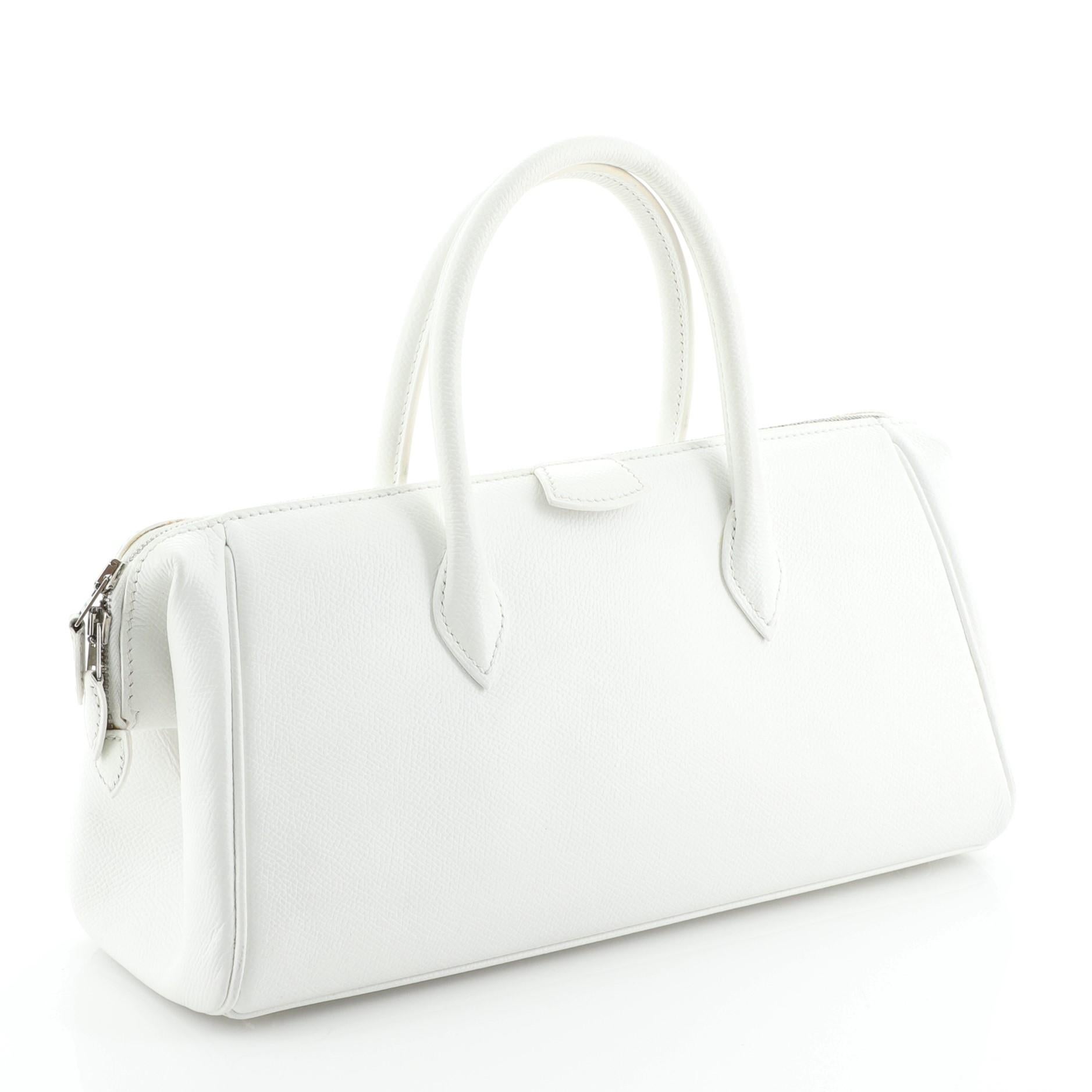 This Hermes Paris Bombay Satchel Epsom 27, crafted in white Epsom leather, features dual rolled handles and palladium hardware. Its zip closure opens to a Natural neutral Agneau leather interior with slip pockets. Date stamp reads: J Square (2006).