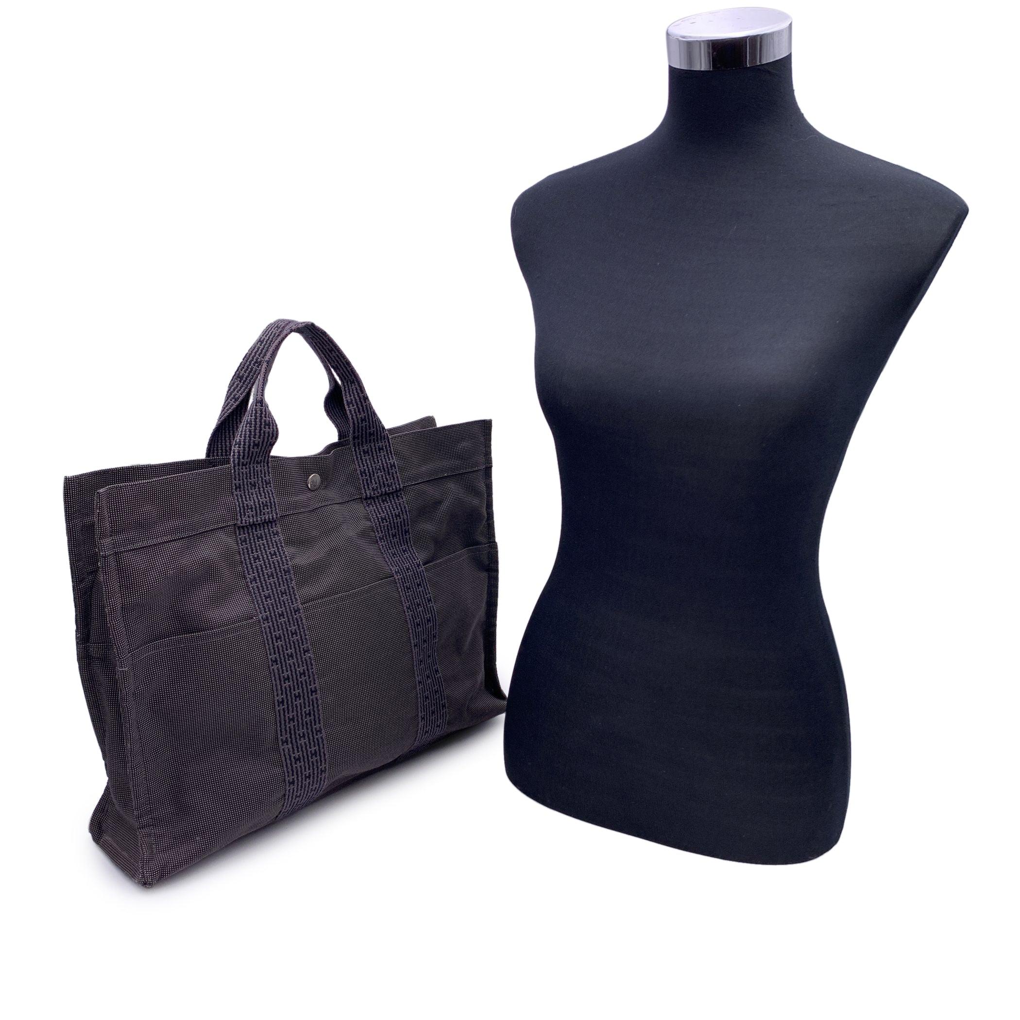 Hermes Canvas Herline Her Line Yale MMTote Bag in grey and black colors. Made of a durable canvas. The tote has durable strap handles of a patterned Hermes H canvas. 3 open pockets on the front. Composition; 69% Polyamide, 31% Polyester. 3 snap