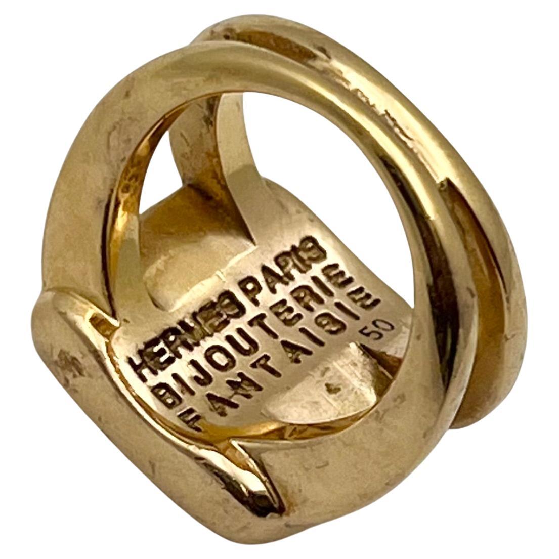 
The  'Corozo' ring by Hermès Paris - Circa 2000. Carved intaglio of equestrian horse and rider scene in brown on white background.  Square cushion top design measuring 16-17mm having split double band shank.  The underside interior is signed