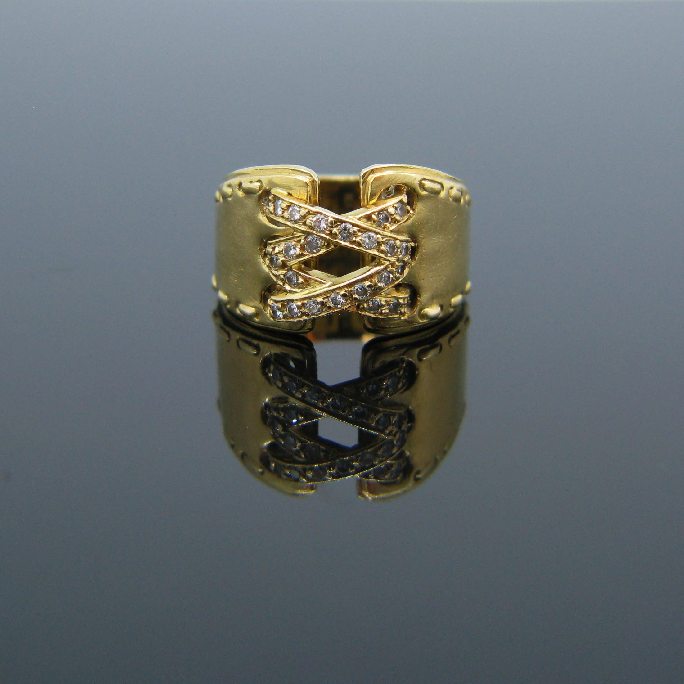 This ring is signed by the famous designer house Hermes. It is called the corset ring and is made in 18kt yellow gold. This vintage ring features a stitch design on the both sides of the band. It is set with 28 round cut diamonds with a total carat