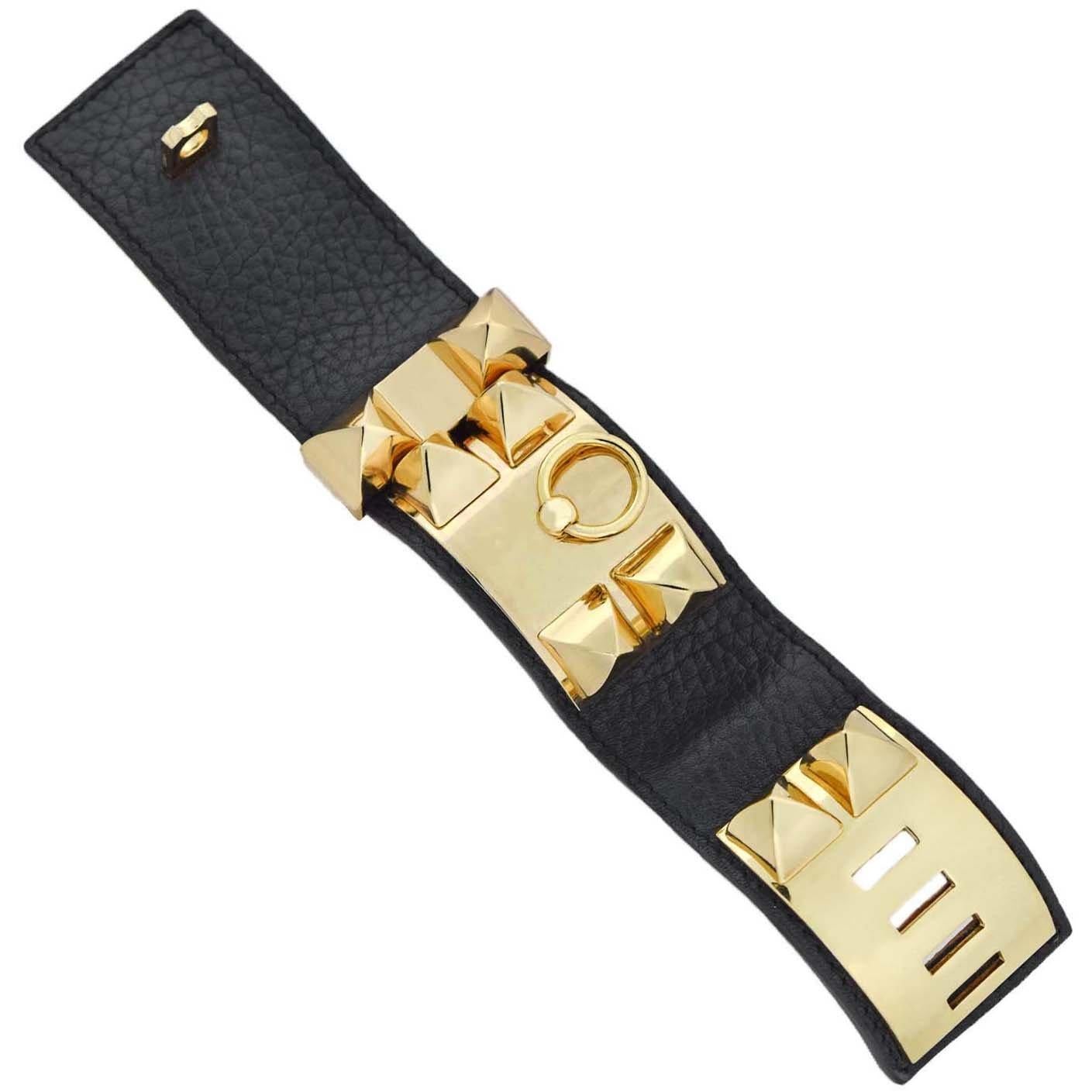 This striking Estate bracelet is a signed piece from Hermés Paris! Known as the Collier de Chien bracelet, this wide, wrap around cuff is crafted out of Epsom calfskin black leather with fabulous gold-tone accents. Adorning the front of the piece is