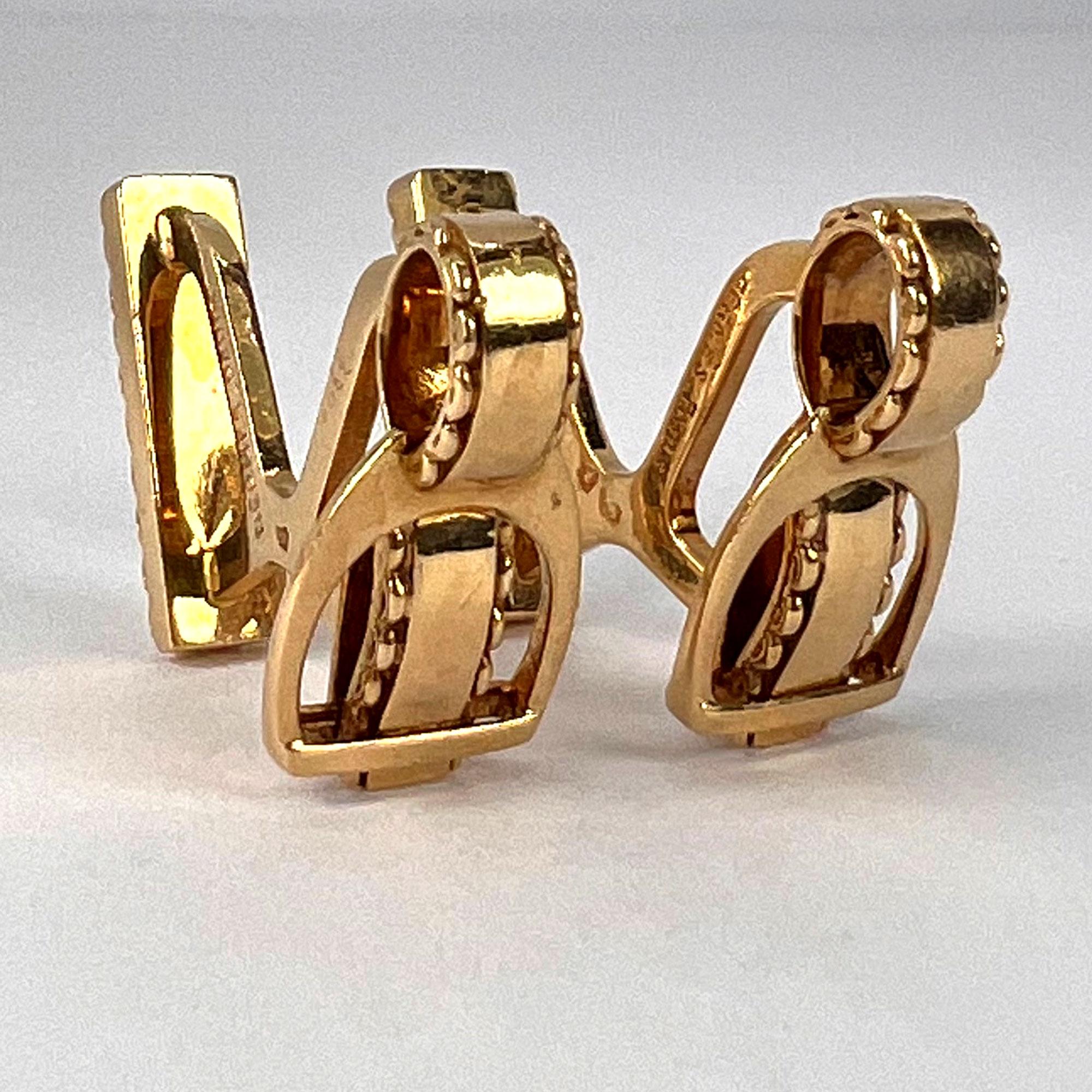A pair of 18 karat (18K) yellow gold cufflinks, each designed as a stirrup on a leather strap, with a solid back. Signed Hermes Paris, stamped with the eagle mark for 18 karat gold and French manufacture, maker’s mark for Atlor and scratch numbered