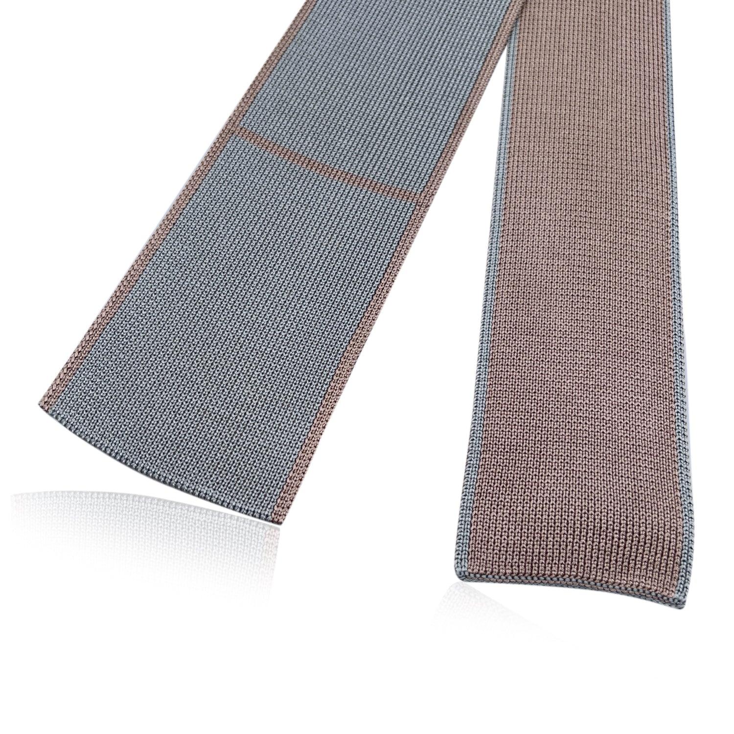 Elegant Hermes 'Maille de Soie' Neck Tie in grey and beige silk. 100% knit silk. Reversible design. Composition: 100% Silk. Hermes composition tag attached. Made in Italy. Total length: 55.5 inches - 141 cm. Max width: 3 inches - 7.5 cm Details