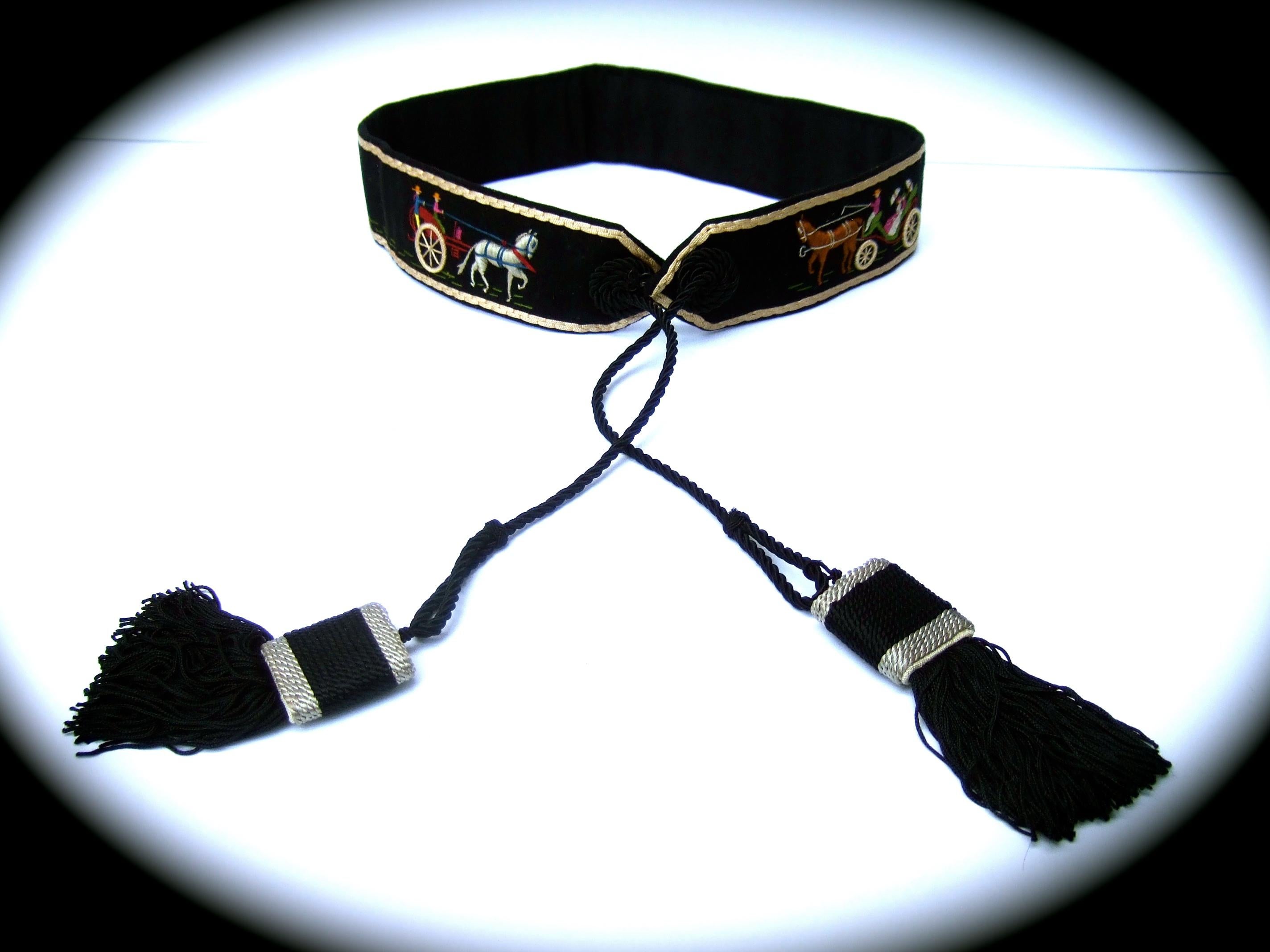 Hermes Paris Rare handmade cloth artisan embroidered tassel belt c 1970s 
The unique black cloth wool belt is embellished with three individual embroidered
scenes featuring horse drawn carriages. The lower section is accented with green 
hand