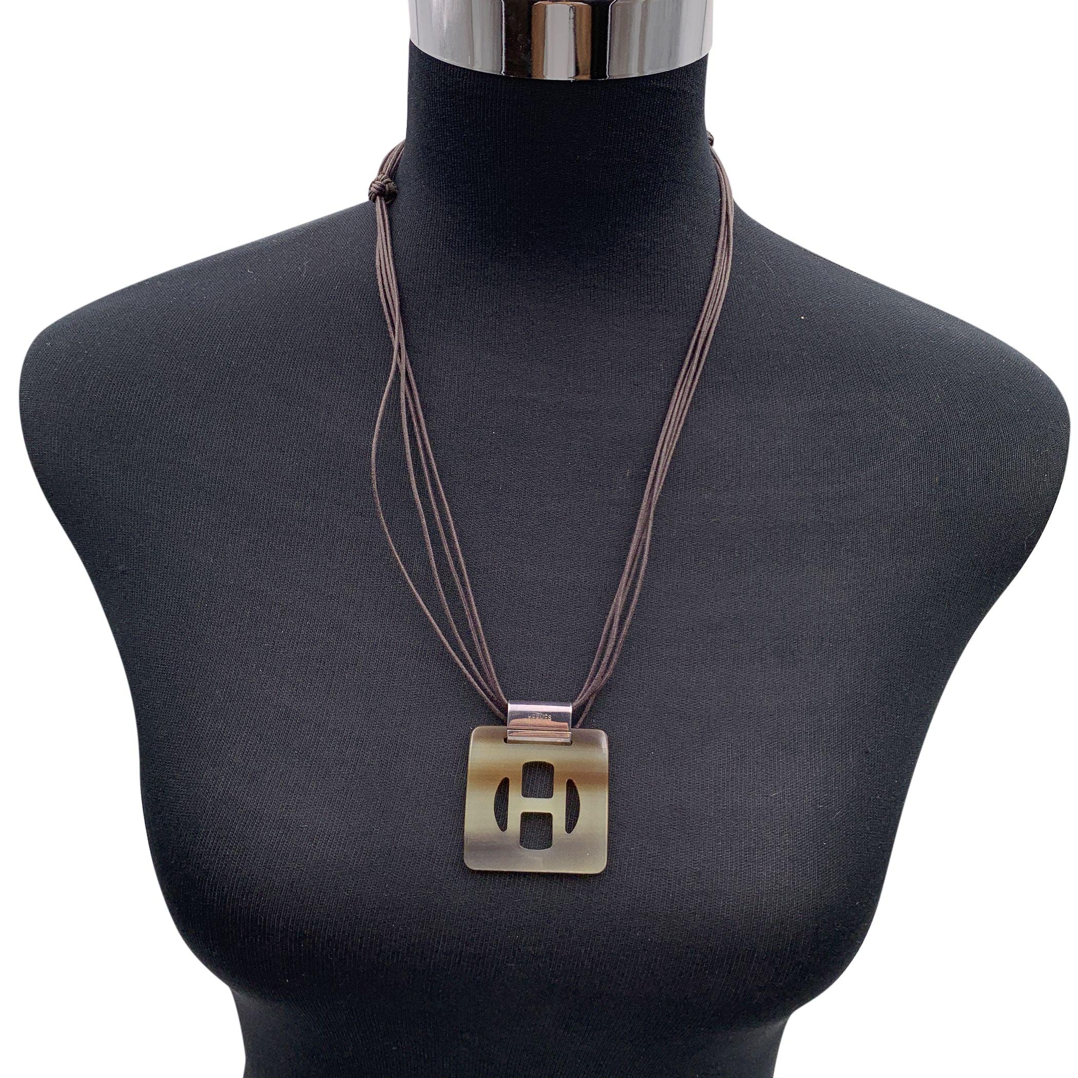 Collier Horn H de Hermes. Pendentif en H de forme carrée avec quincaillerie en silvetone. Collier réglable en cordon de cuir marron à plusieurs brins. Longueur maximale du collier (approx.). 28.75 inches - 73cm Condition A - EXCELLENT Utilisé avec