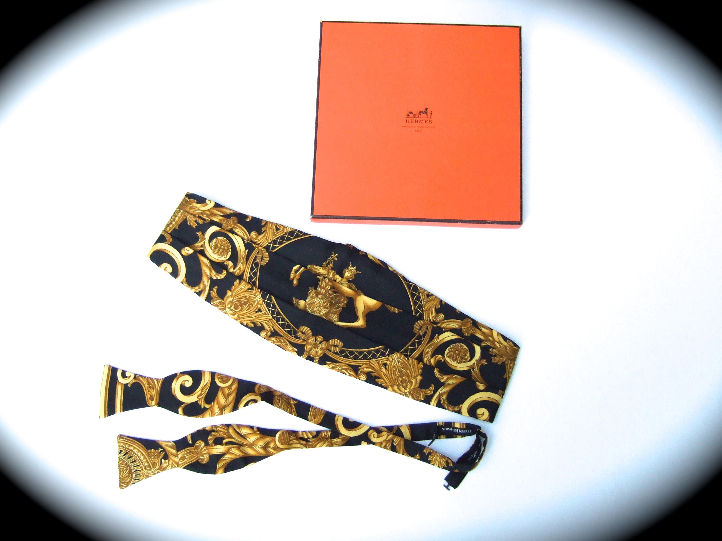Hermes Paris Men's silk cummerbund & bow tie ensemble in Hermes box 
The elegant silk cummerbund set is illustrated with a mythical figure astride a majestic golden yellow horse

The ornate golden yellow scrolled rococo style designs are illuminated